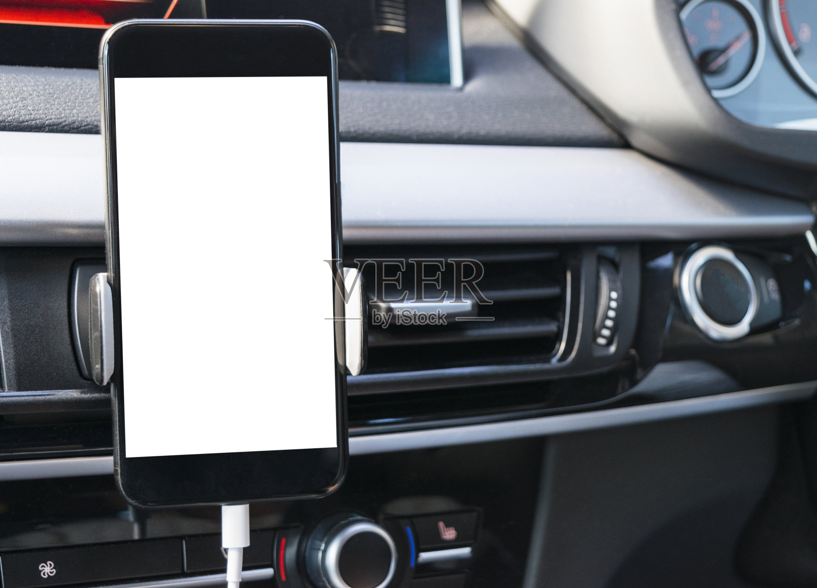 智能手机在汽车中使用导航或GPS。驾驶一辆装有智能手机的汽车。手机与孤立的白色屏幕。空白的空屏幕。副本的空间。文本的空白。现代汽车内部细节。照片摄影图片