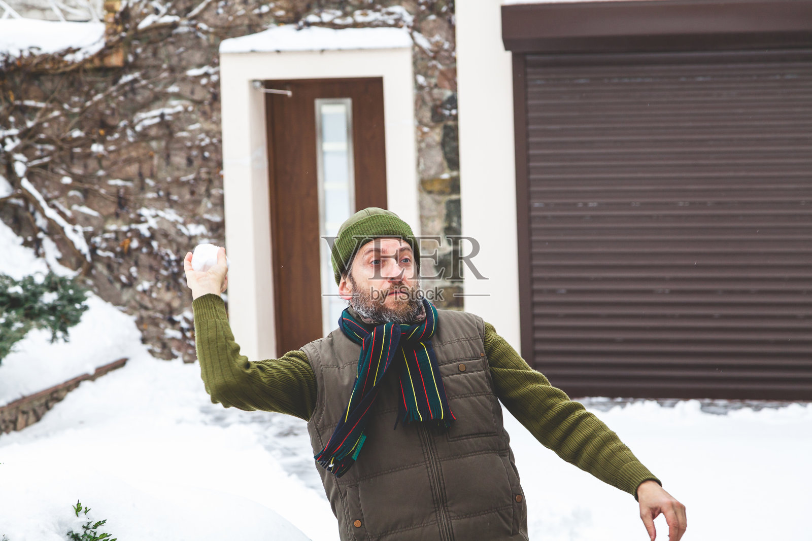 帽子上有胡子的人在院子里扔雪球照片摄影图片
