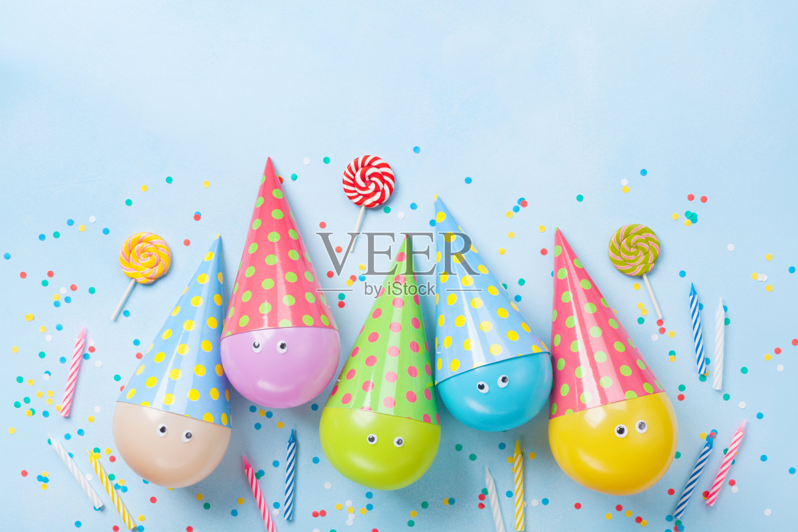 生日或派对背景。有趣的气球，糖果和五彩纸屑在蓝色桌面视图。平的。照片摄影图片
