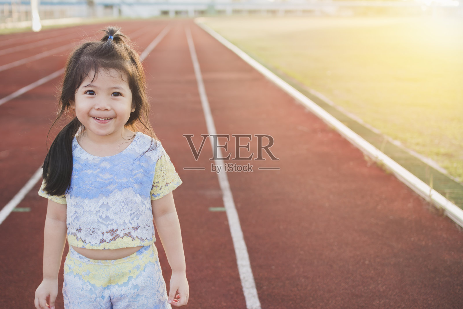 可爱的亚洲女孩穿着运动服正在为健康跑步做准备。在阳光明媚的傍晚。照片摄影图片