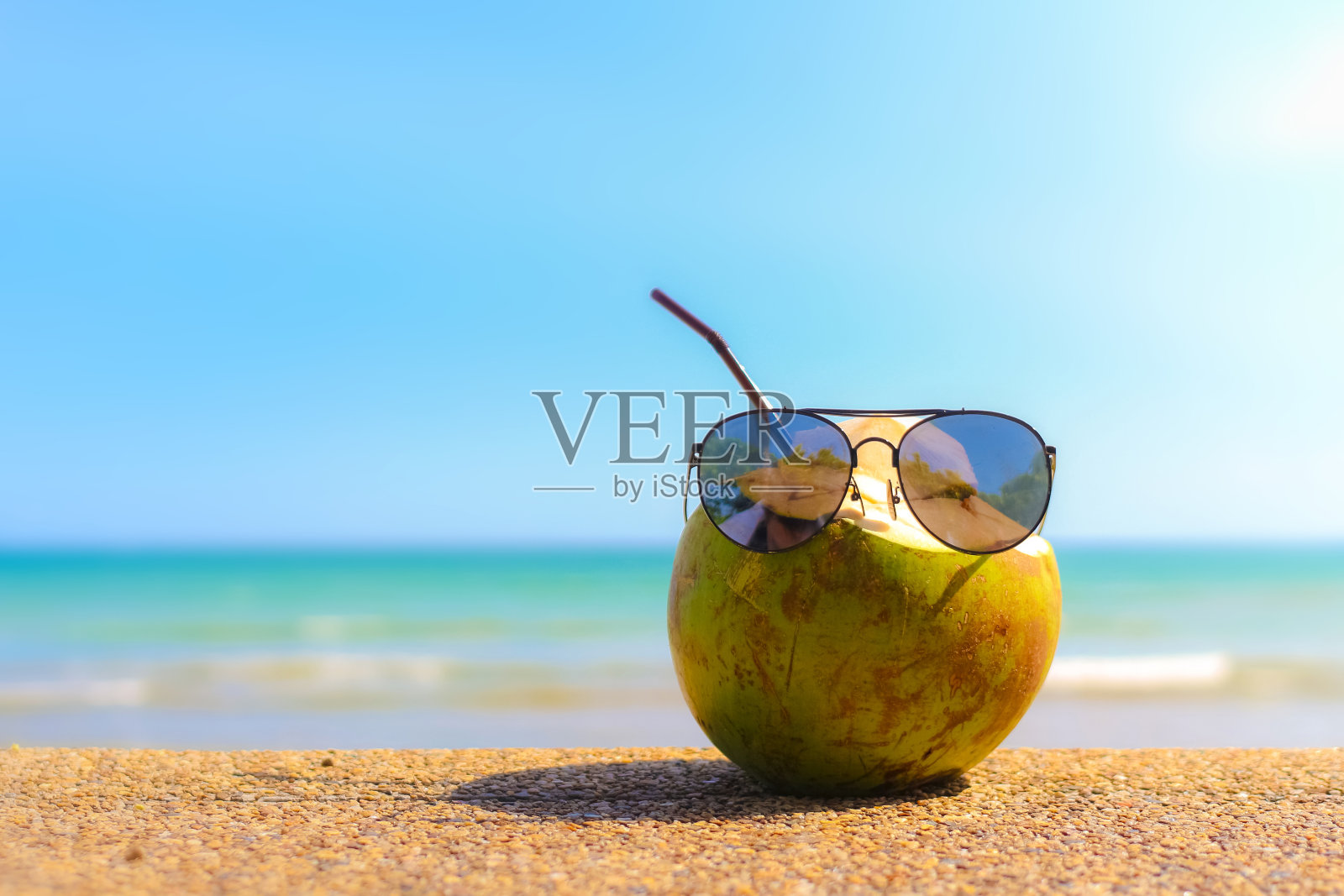 沙滩上戴着太阳镜的椰子照片摄影图片