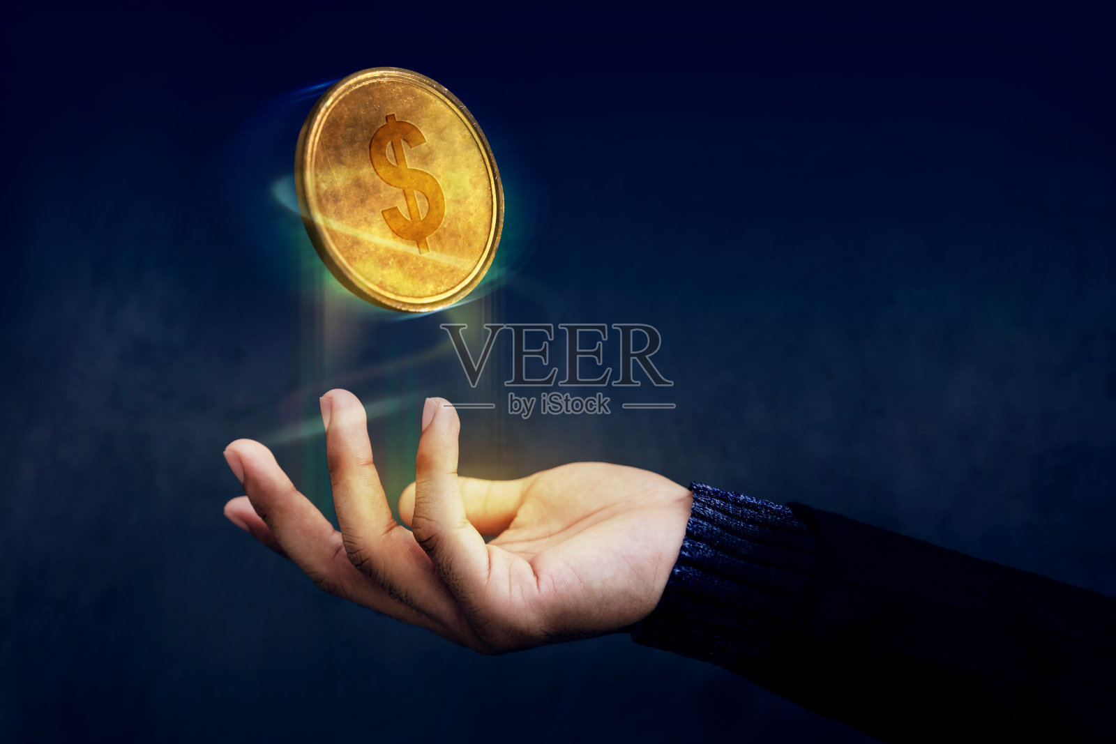 金融或利润作为简单的概念，黄金钱硬币浮在魔术师的手上像一个魔术，黑暗的光照片摄影图片