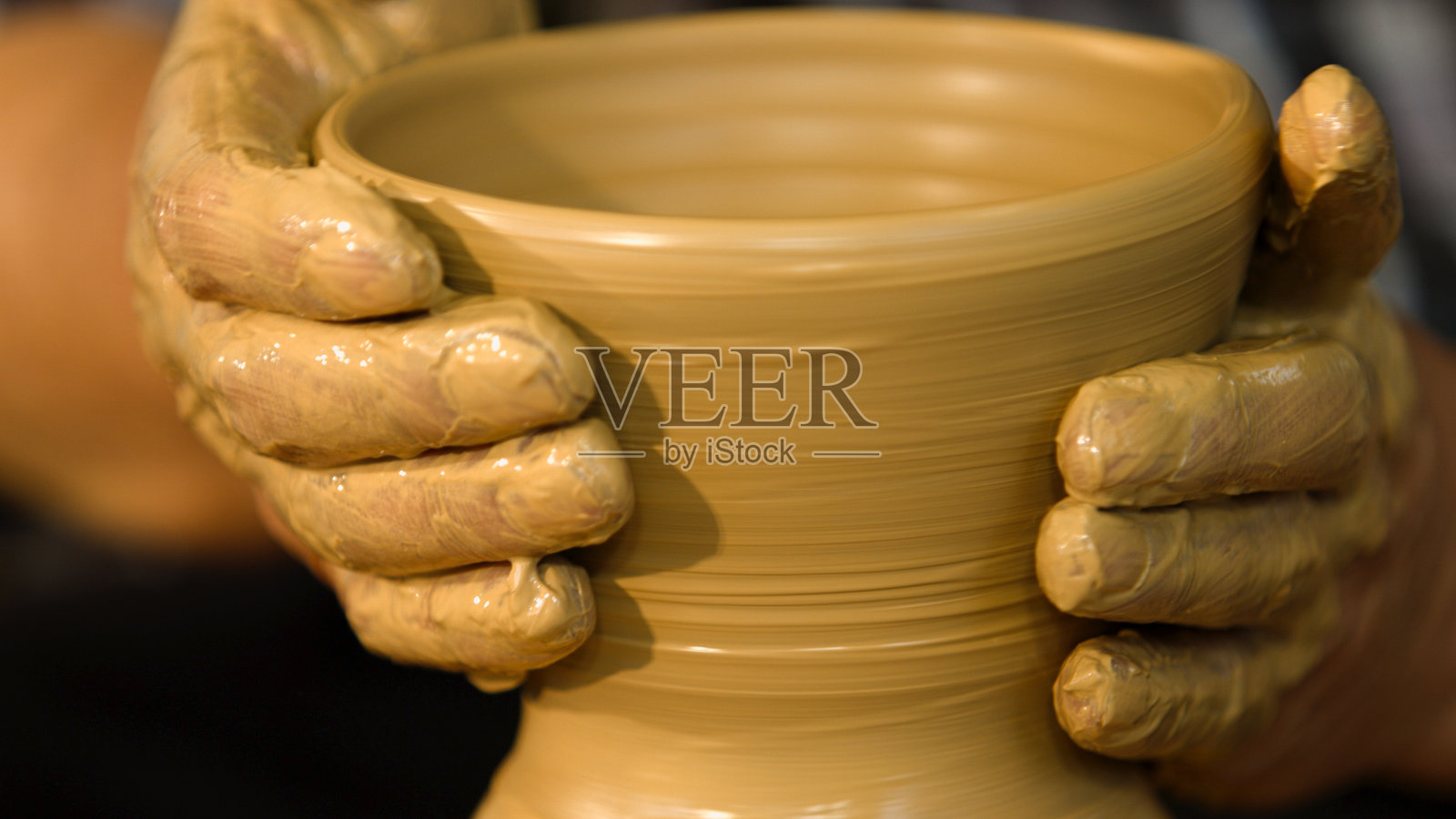 一个工匠的手制作陶器的特写镜头。照片摄影图片
