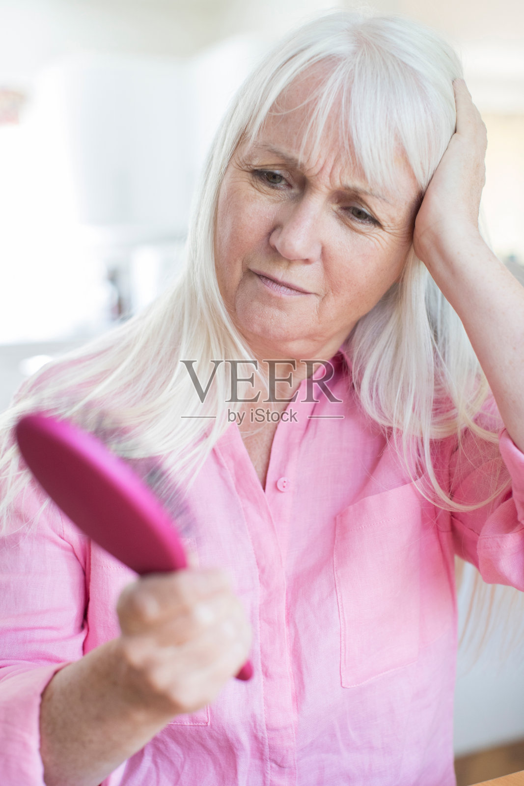 老女人用刷子担心脱发照片摄影图片