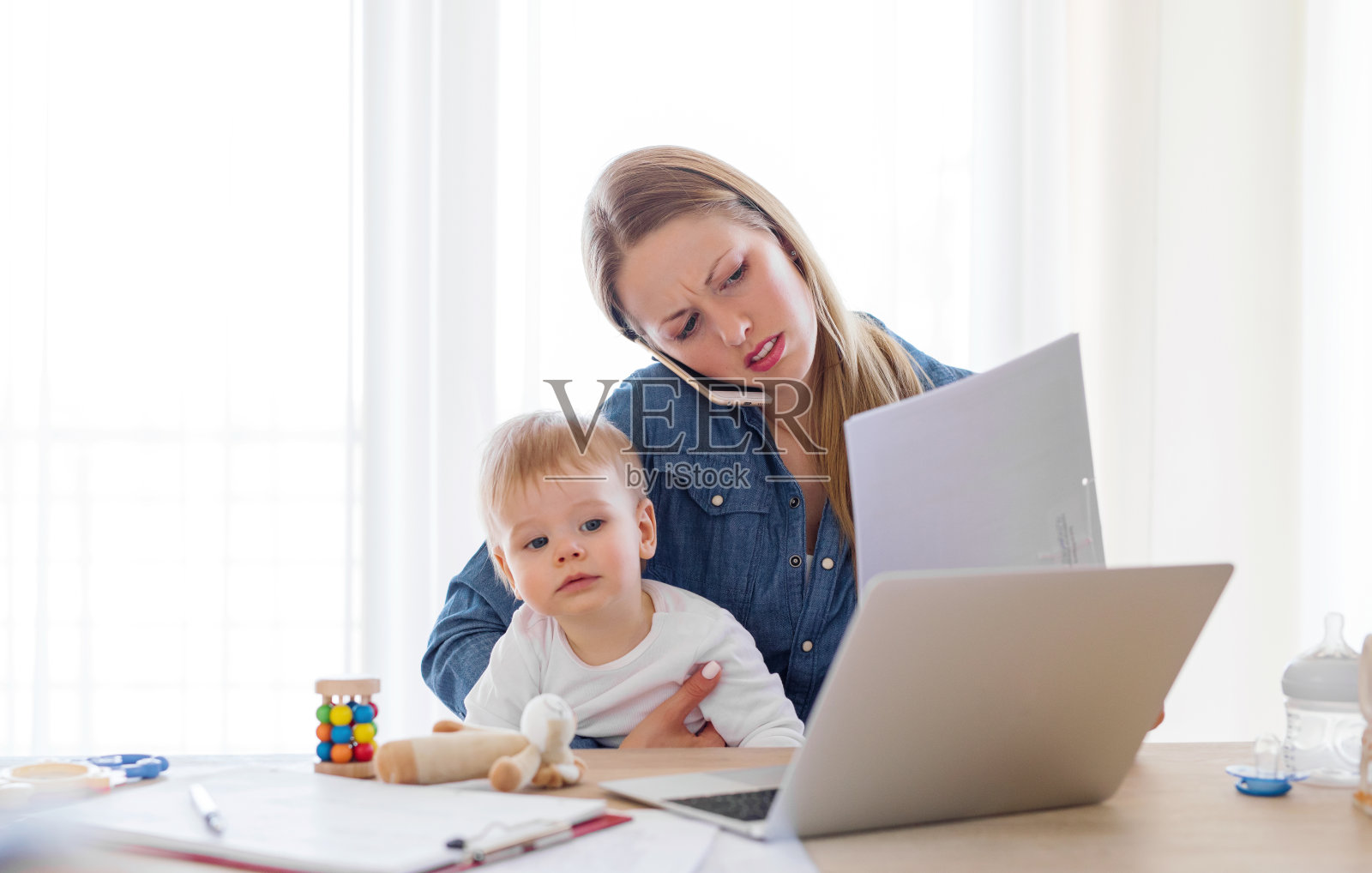 母亲抱着孩子在家用电脑工作照片摄影图片