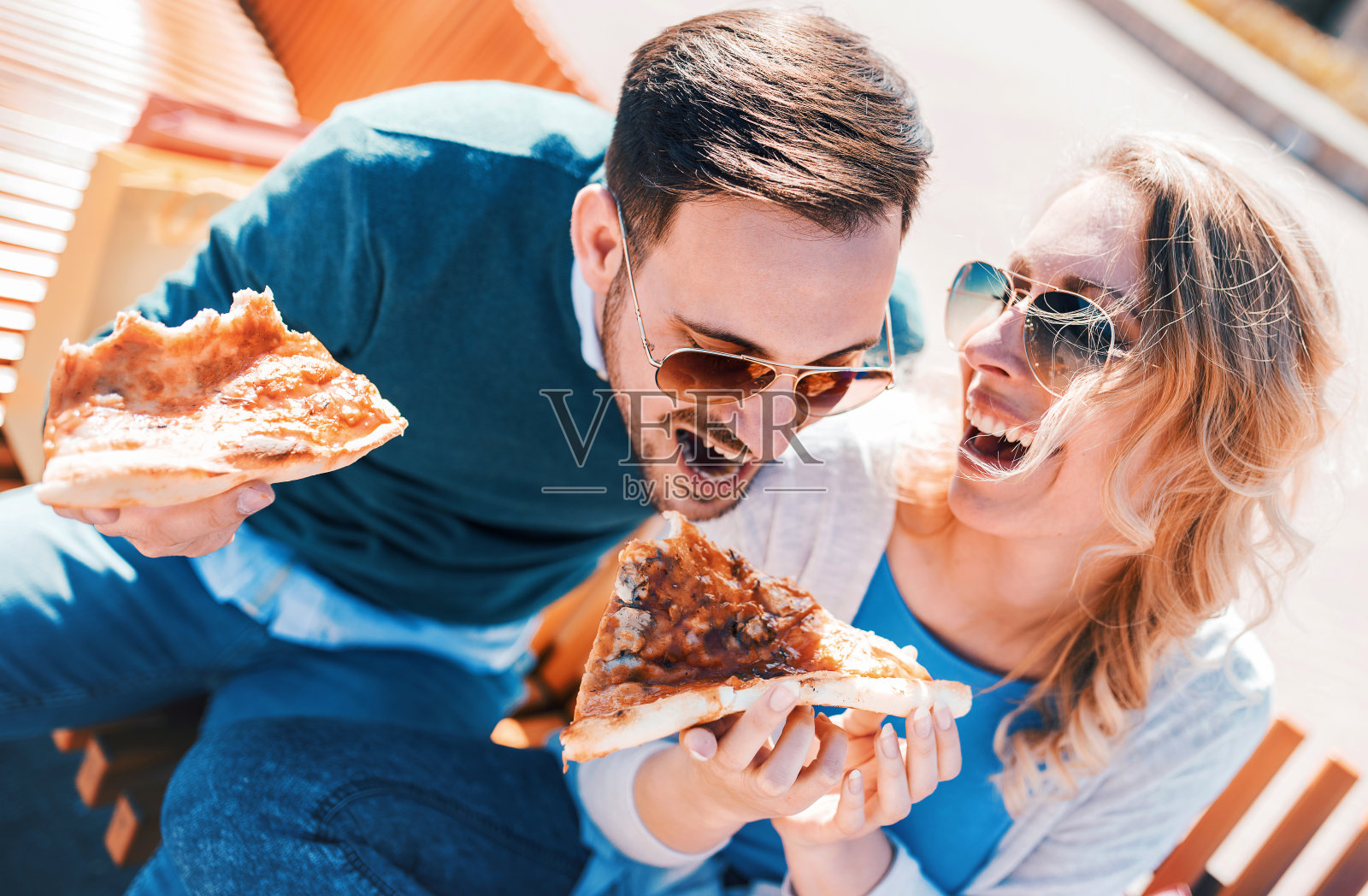 一对情侣在户外吃披萨。约会，消费主义，食物，生活方式概念照片摄影图片