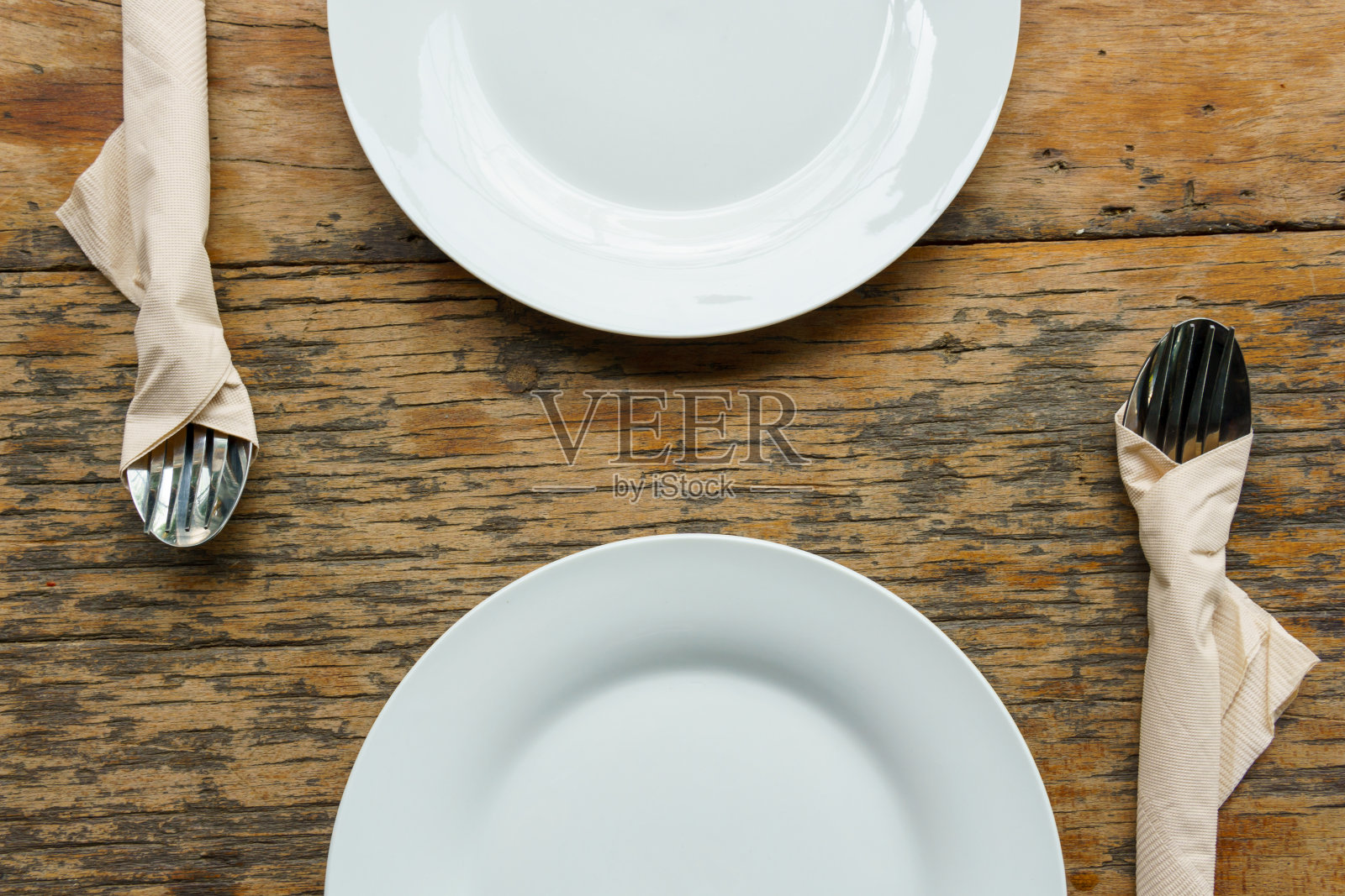 前视图。旧木桌上放着两个带刀叉的白色空盘子。食品的概念。照片摄影图片