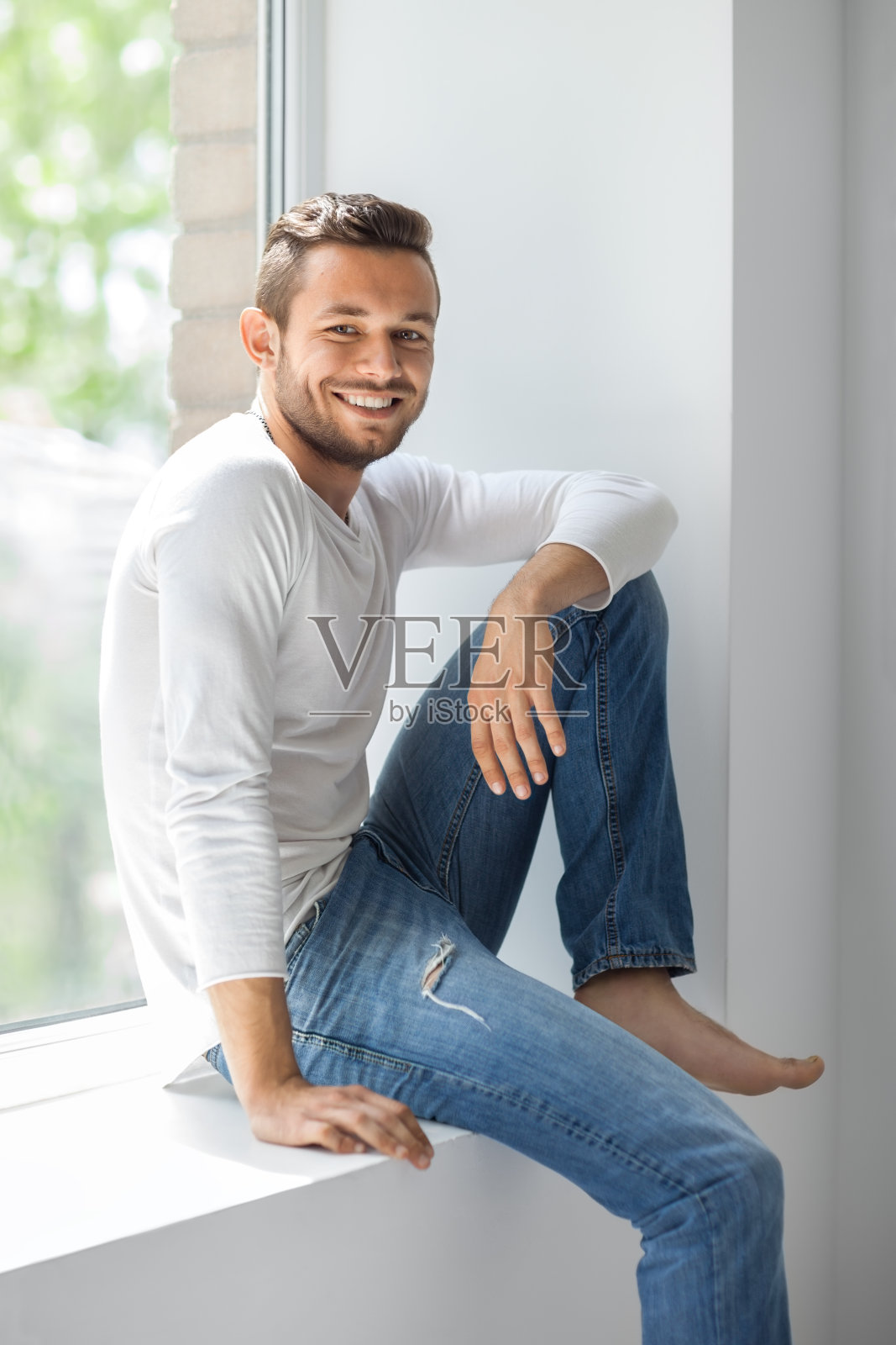 快乐微笑的男人在窗台上休息照片摄影图片