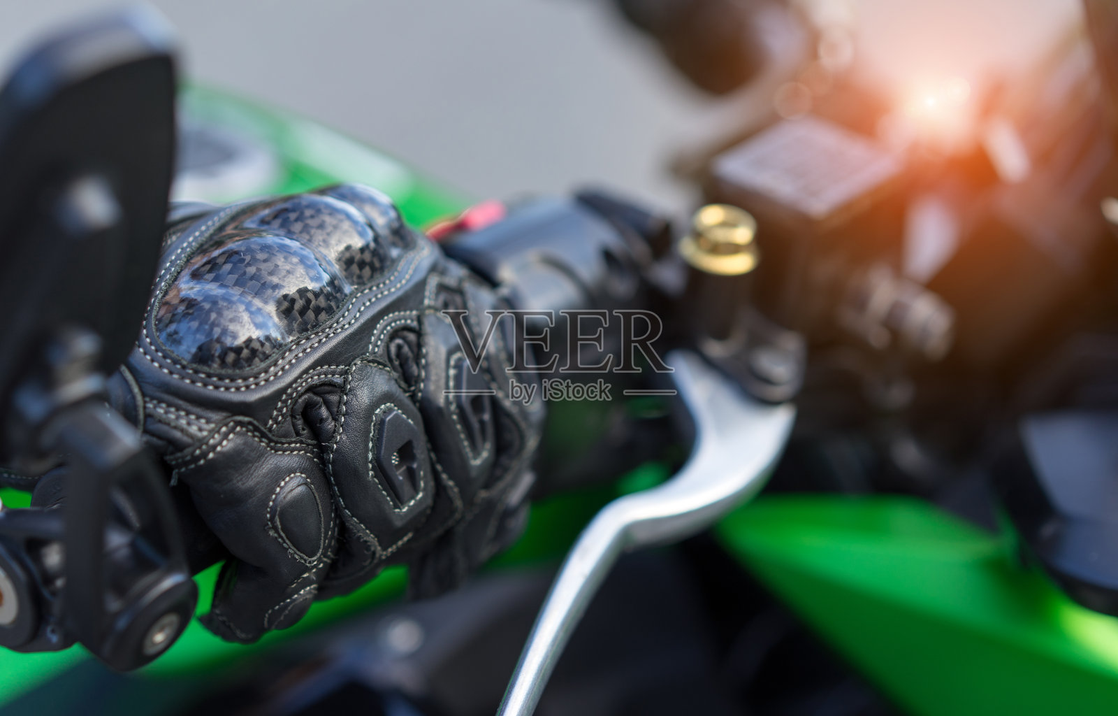 特写女摩托车手与手套安全骑加速速度控制，手握拳手刹车摩托车和自然背景。照片摄影图片