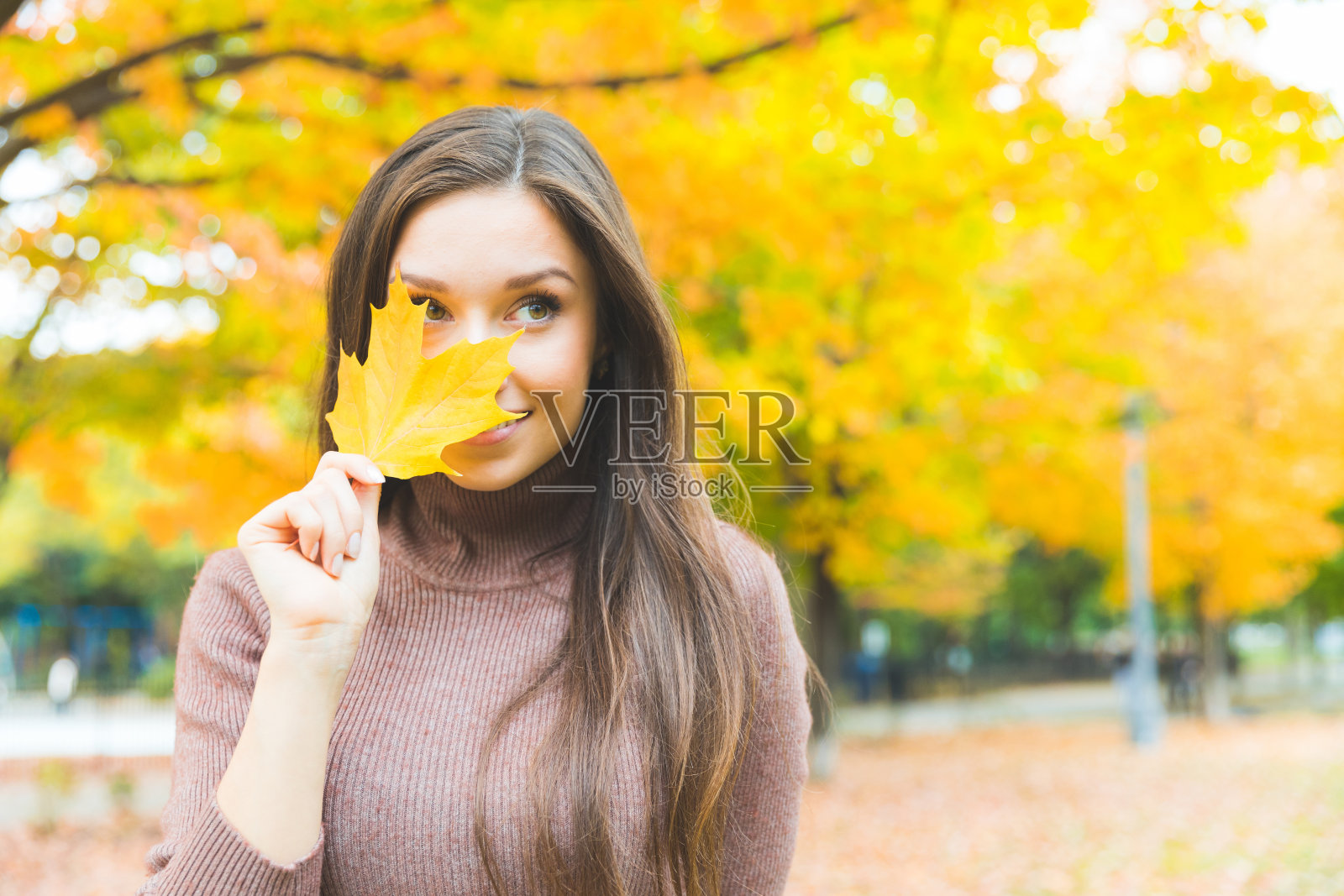 微笑的女人肖像与黄叶在秋天照片摄影图片