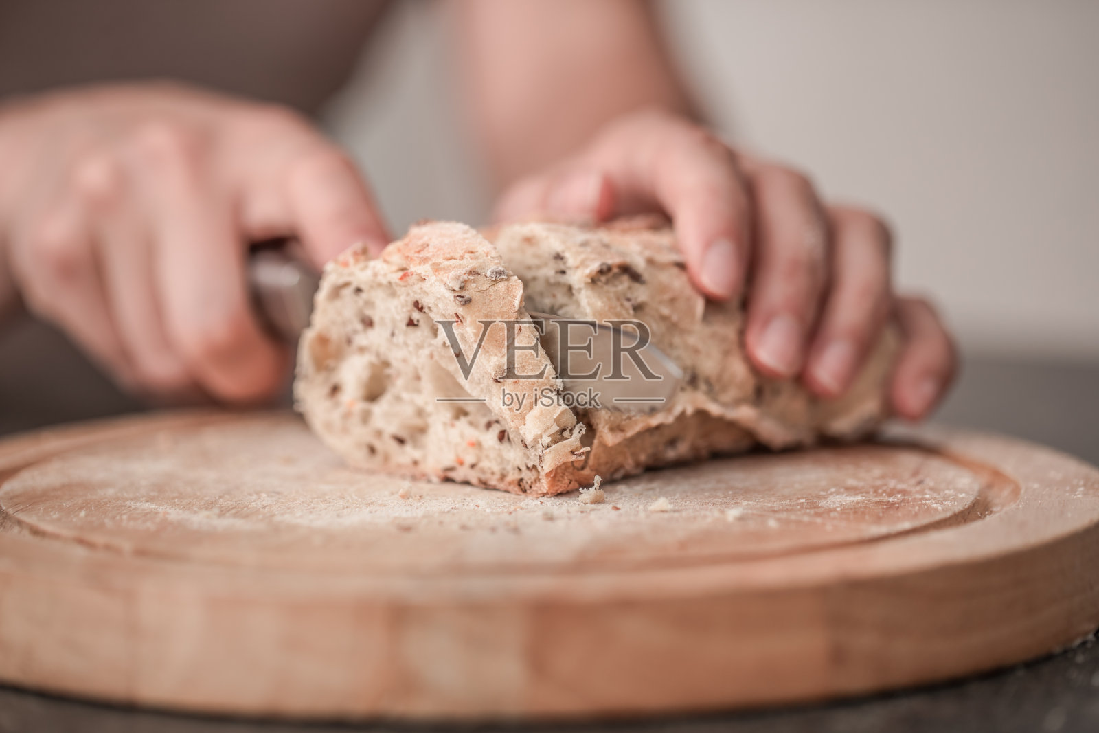 手里拿着新鲜的面包，老木头背景的特写照片摄影图片