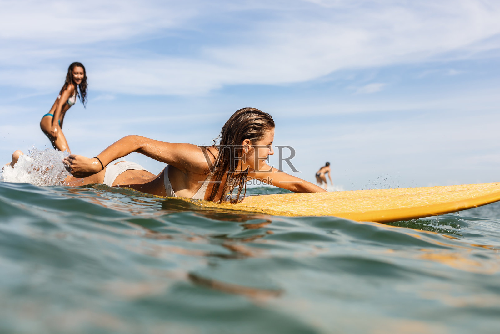两个漂亮的运动女孩在海里冲浪。照片摄影图片