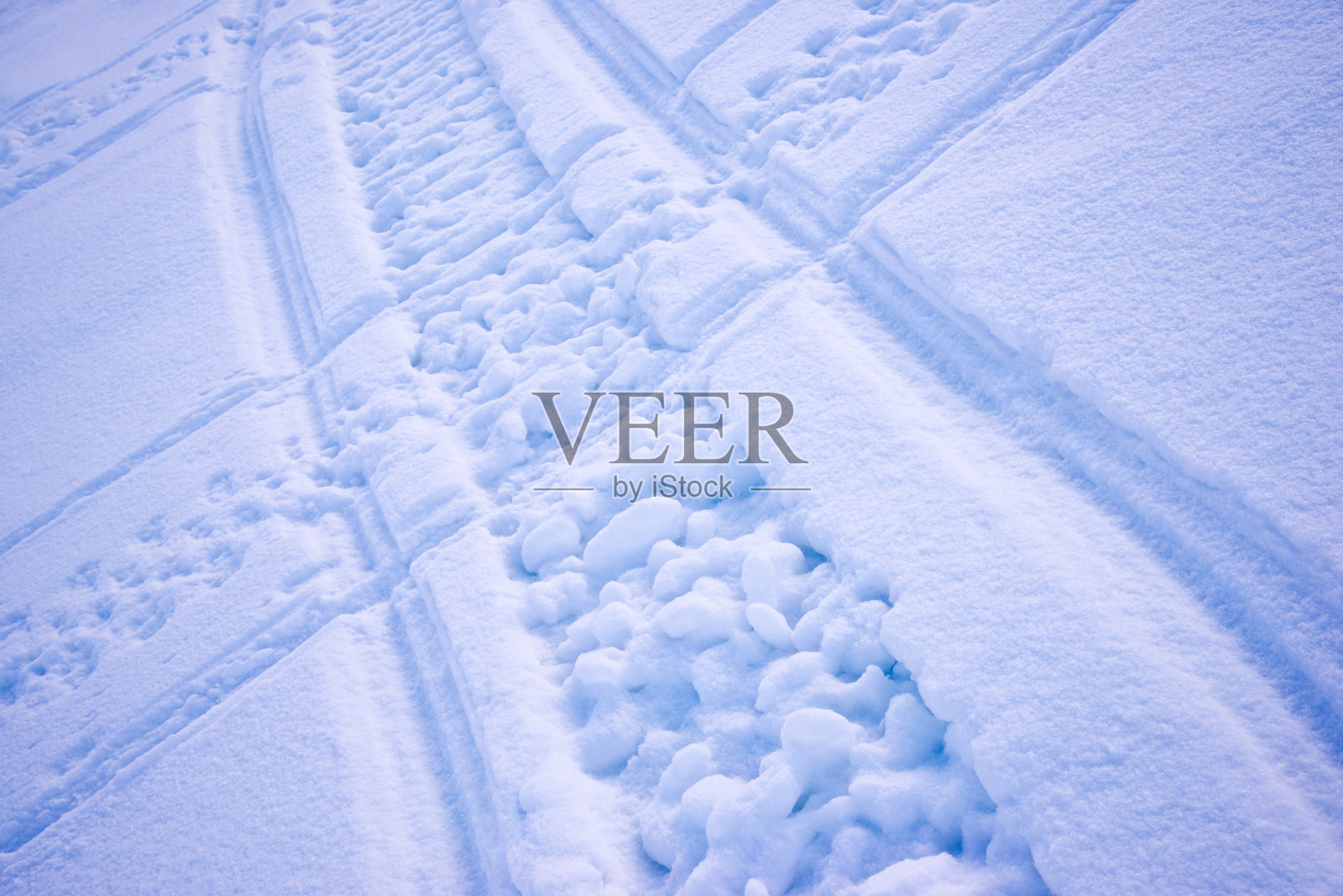 雪地摩托在雪山上的横道作为背景。冬天的季节。照片摄影图片