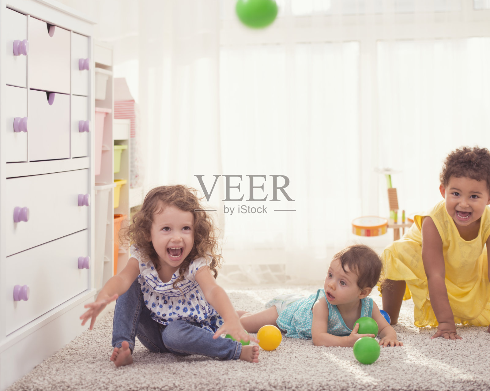三个小女孩在儿童房一起玩。照片摄影图片