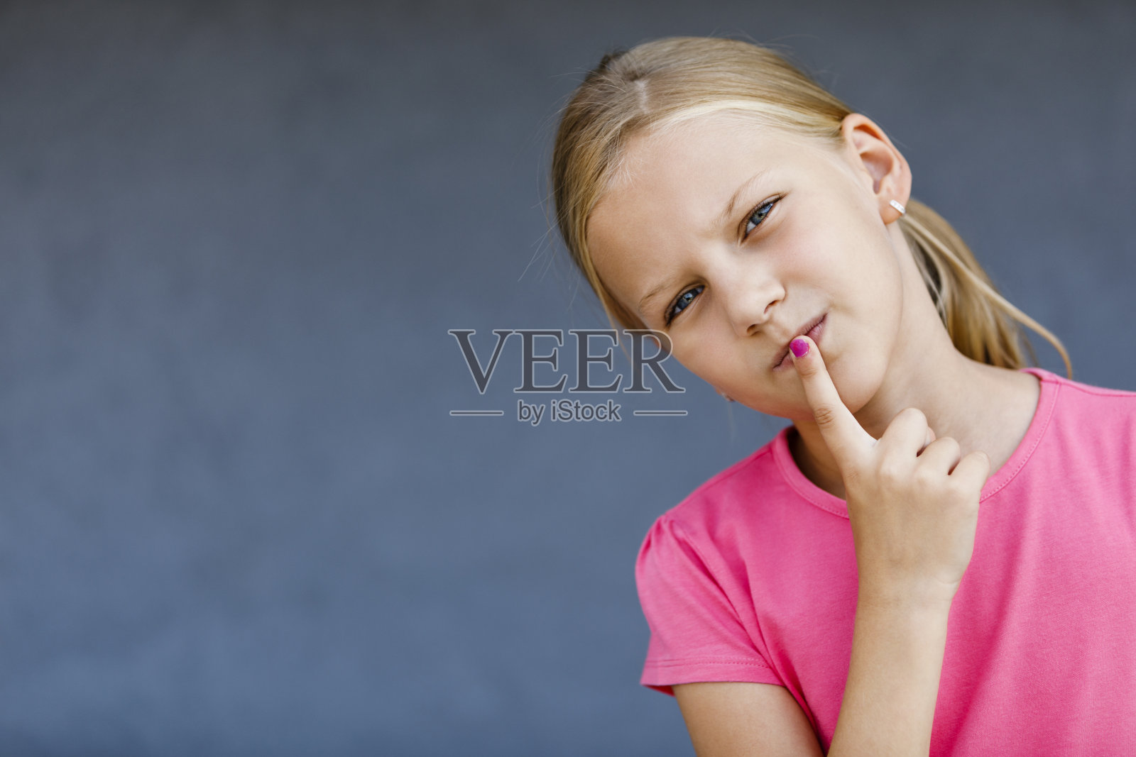 一个年轻女孩把手指放在嘴唇上的肖像照片摄影图片