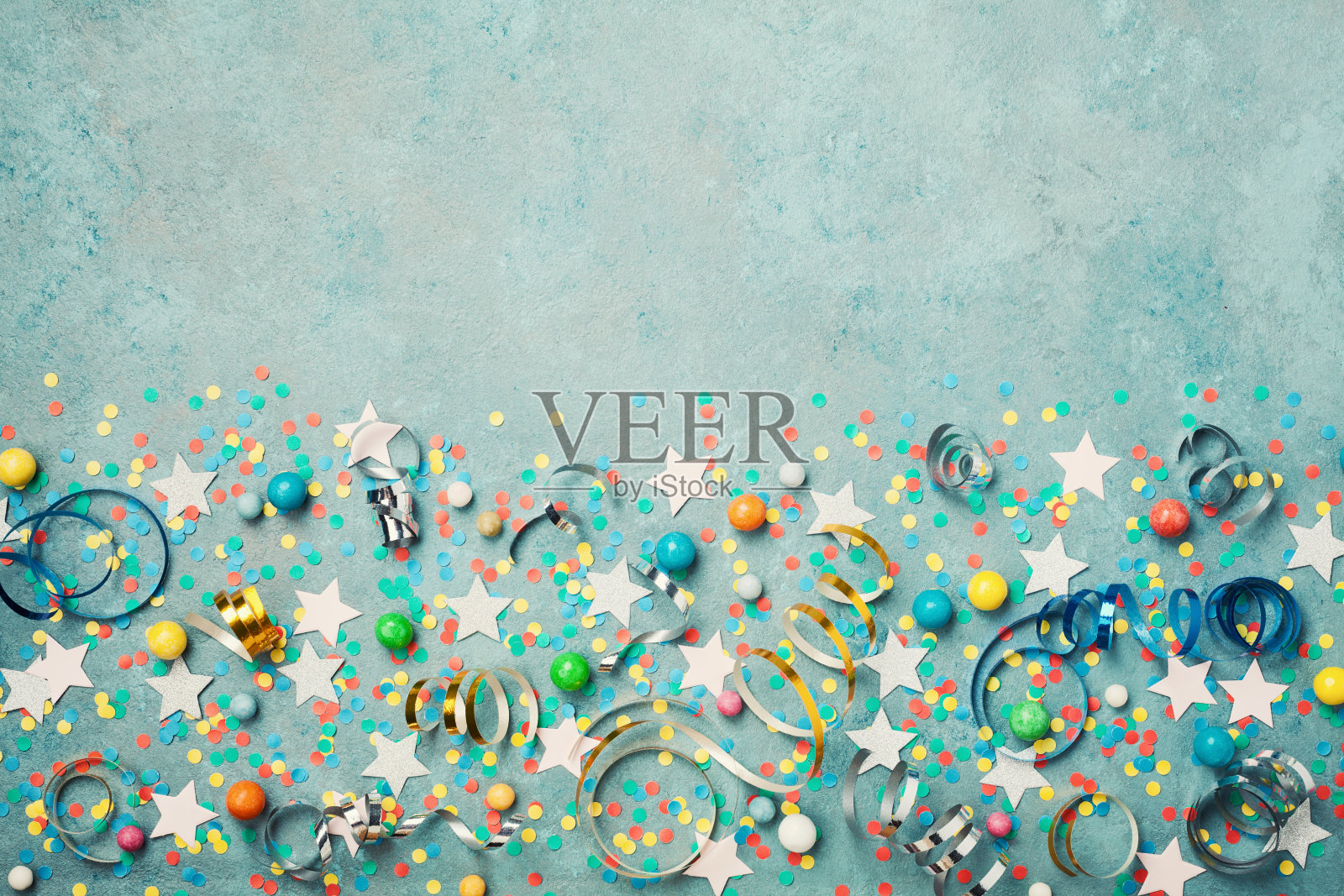 假日背景装饰彩色的五彩纸屑，星星，糖果和流光在蓝色复古桌顶视图。平的风格。照片摄影图片