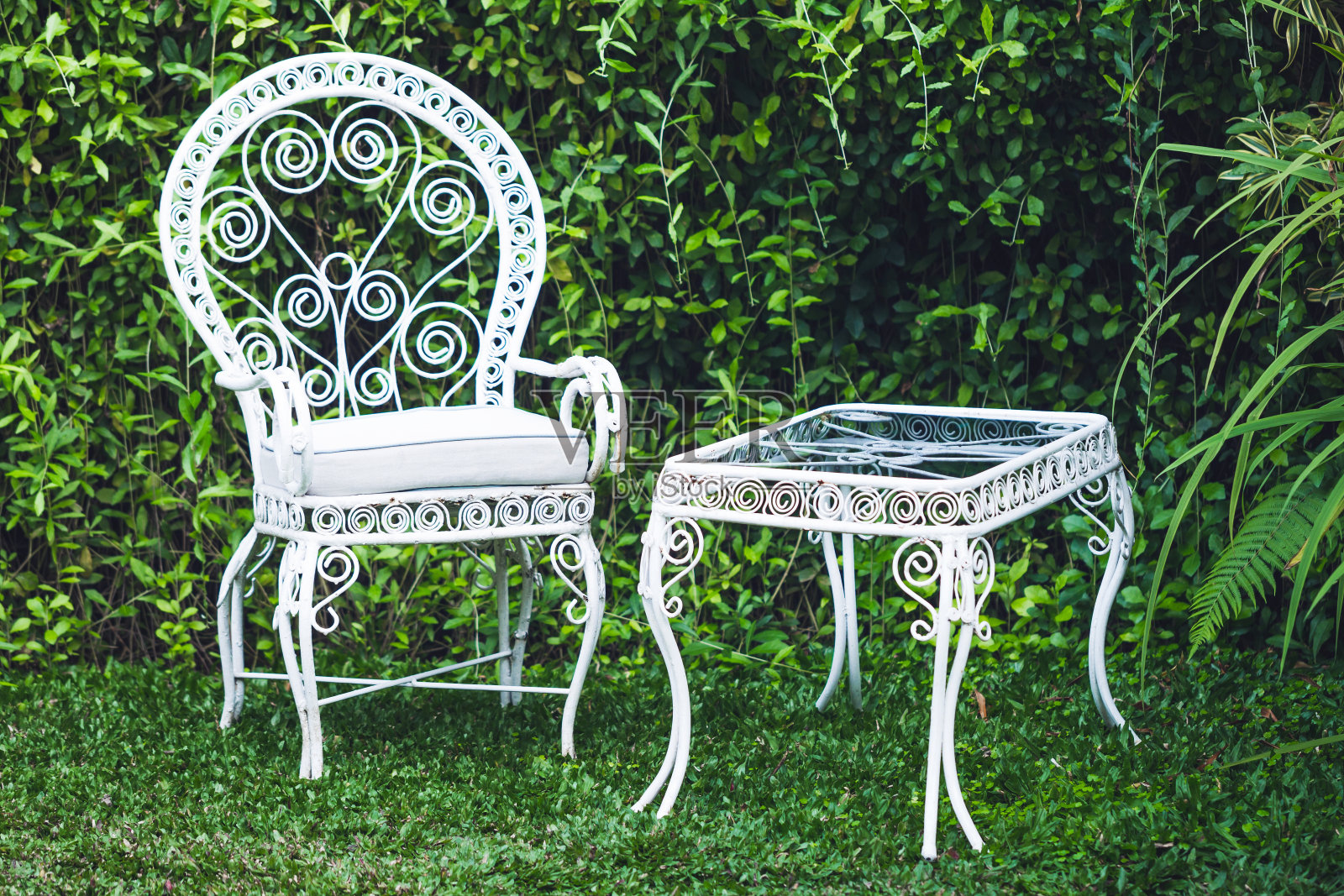 花园里的老式家具，以自然的绿色为背景。白色金属桌椅，老式欧式风格照片摄影图片