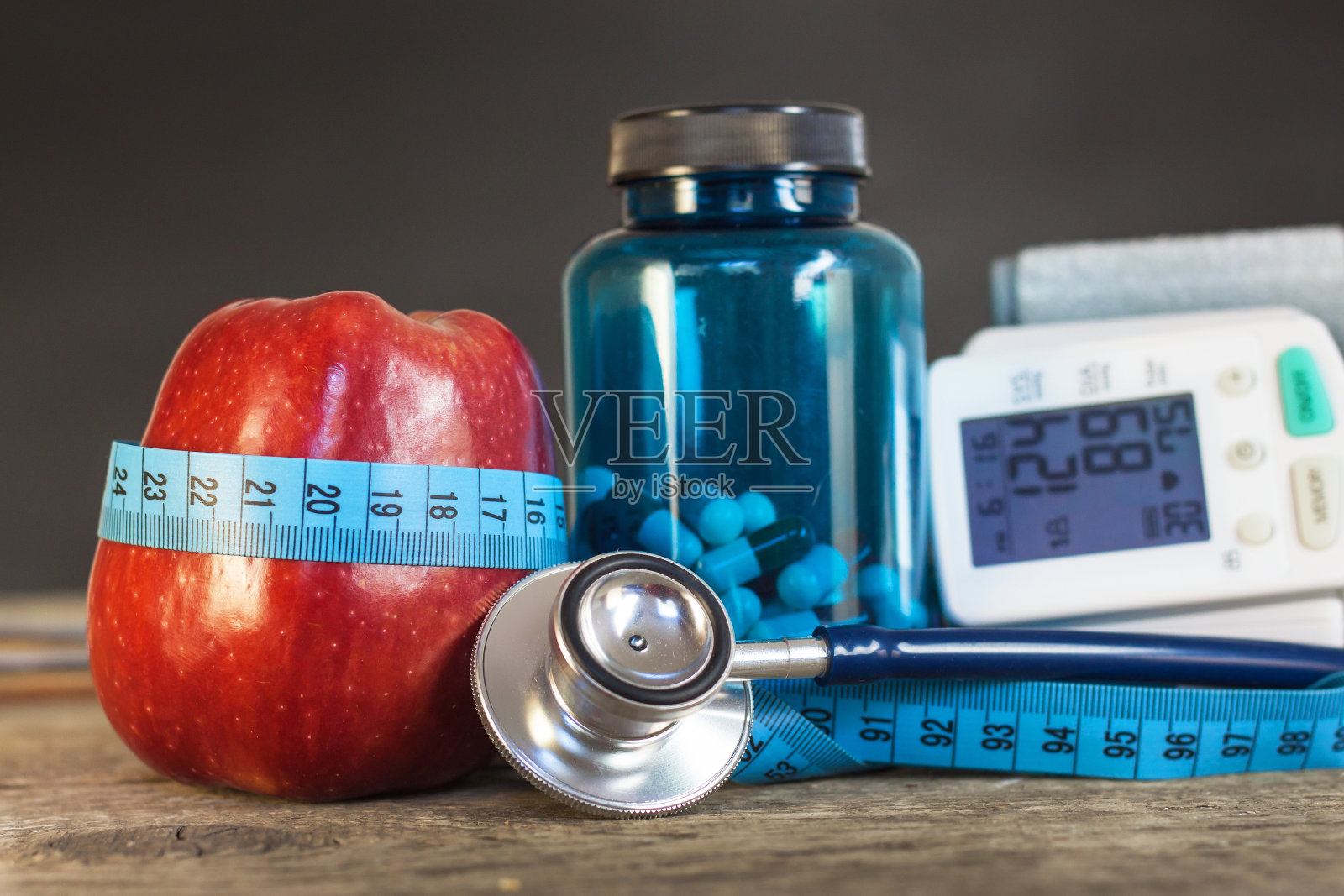 红苹果用卷尺量长度。治疗肥胖和糖尿病，测量血压。照片摄影图片