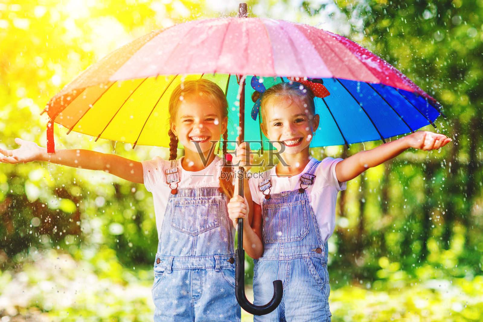 快乐有趣的姐妹双胞胎孩子女孩带伞照片摄影图片