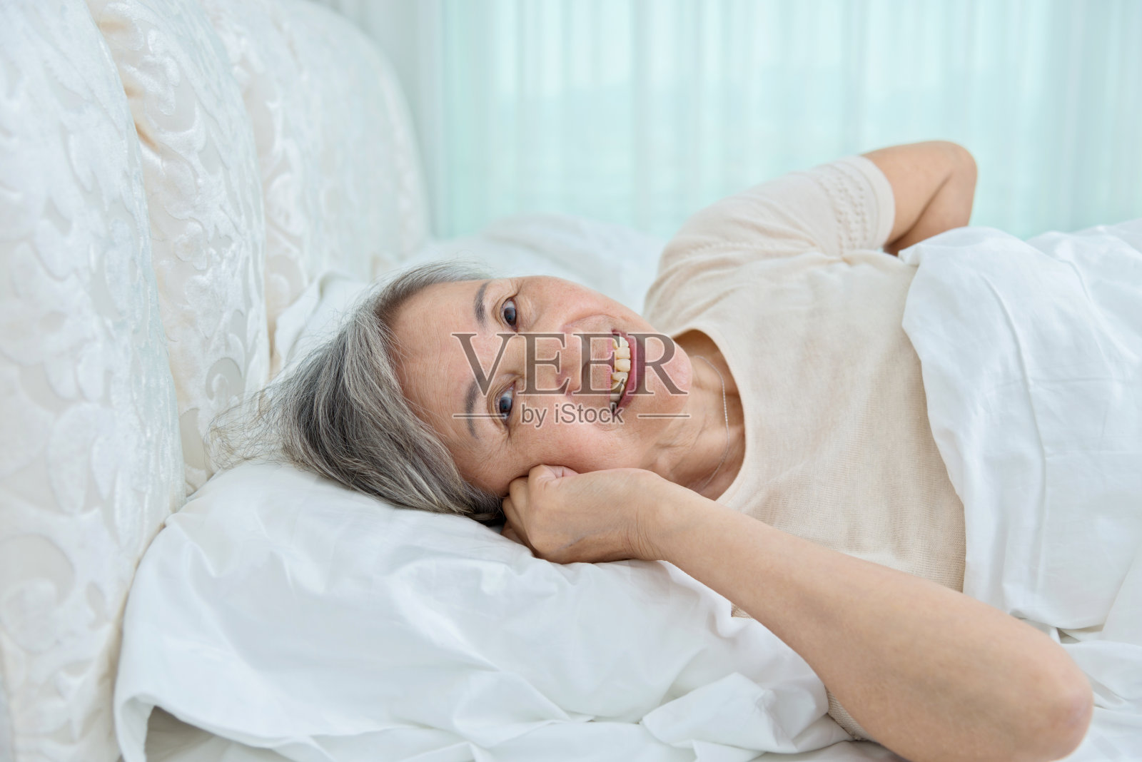 老妇人躺在床上照片摄影图片