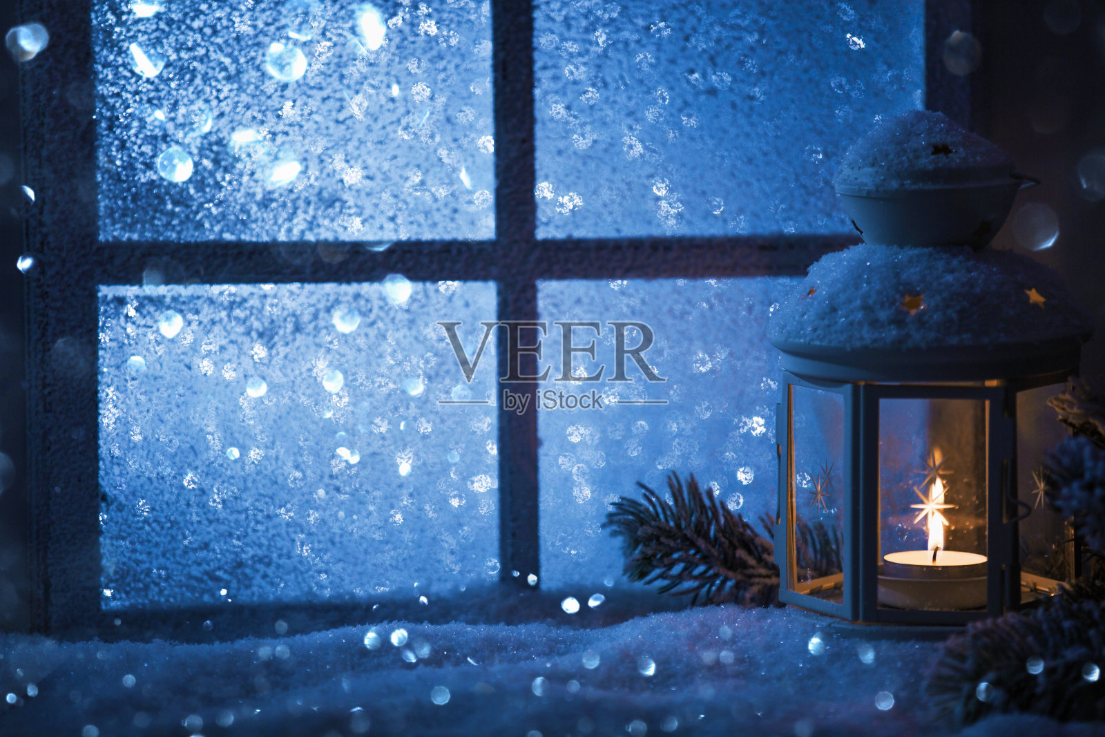 冬季装饰用烛台靠近白雪覆盖的窗户照片摄影图片