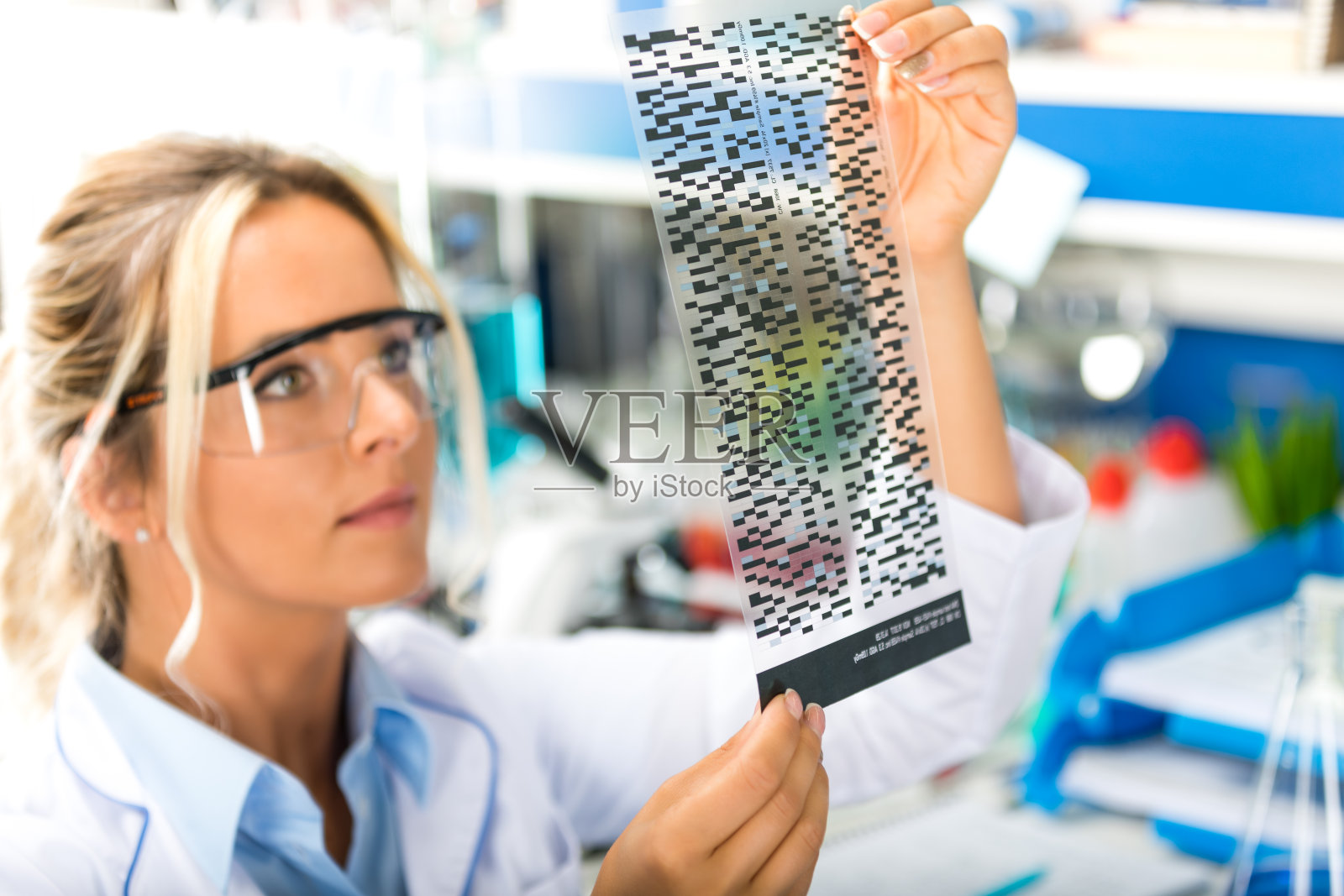 年轻迷人的女科学家正在检查DNA放射自显影结果照片摄影图片