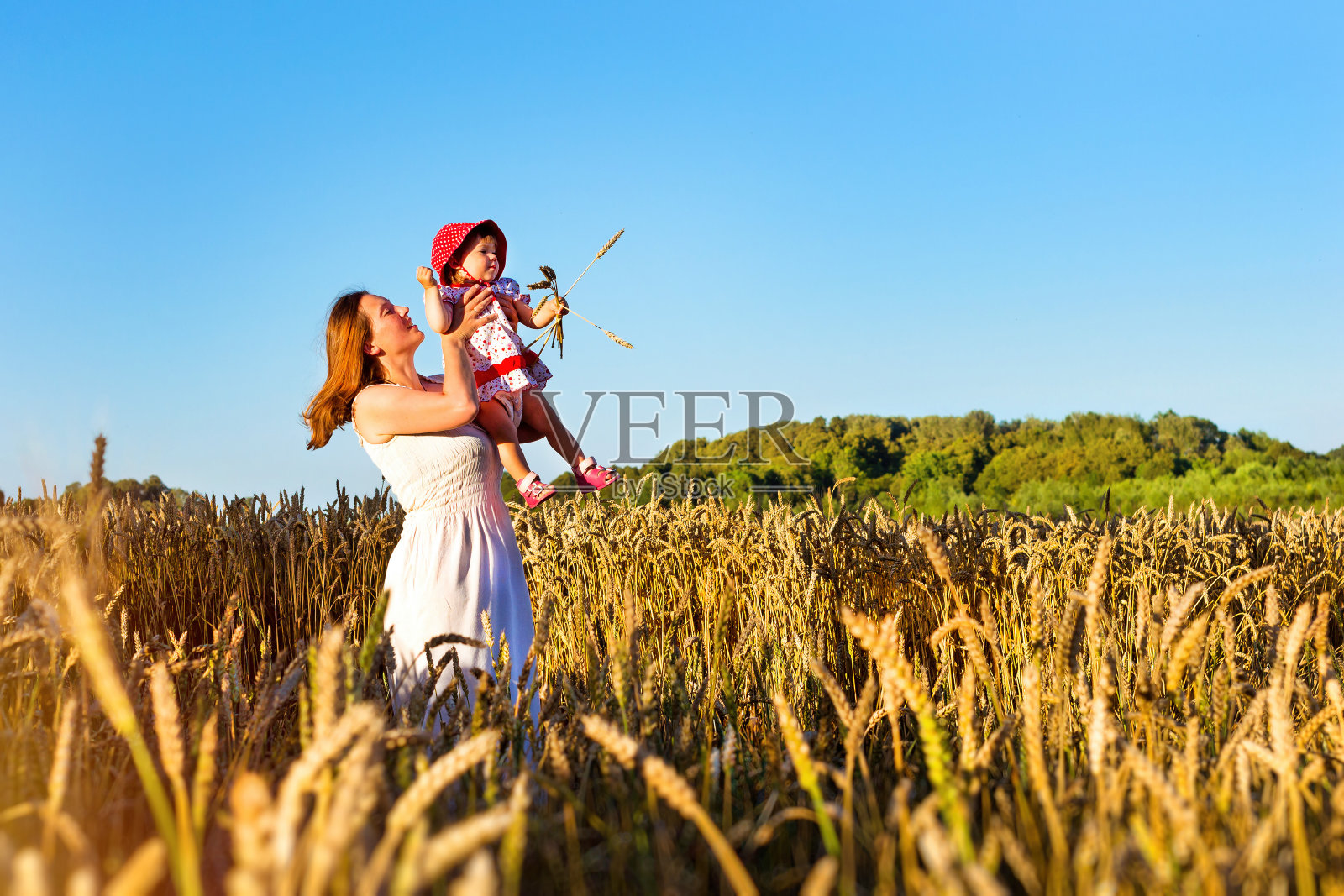 女人和孩子在金色的麦穗地里照片摄影图片