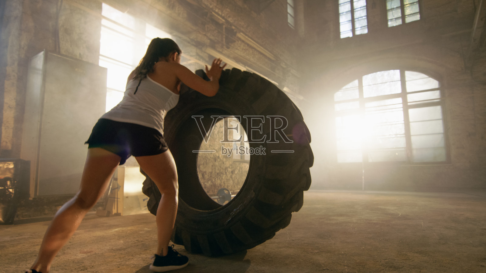 Fit Athletic Woman lift Tire as Part of Her Cross Fitness/健美训练。照片摄影图片