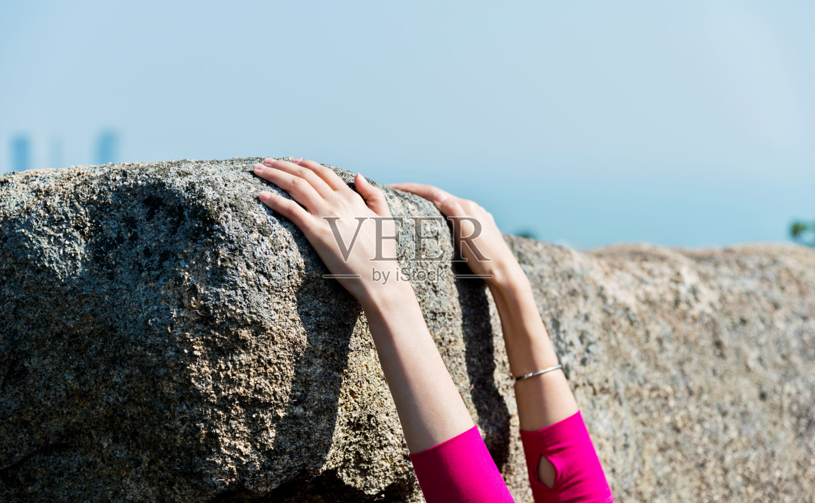 女人的手在岩石的边缘照片摄影图片