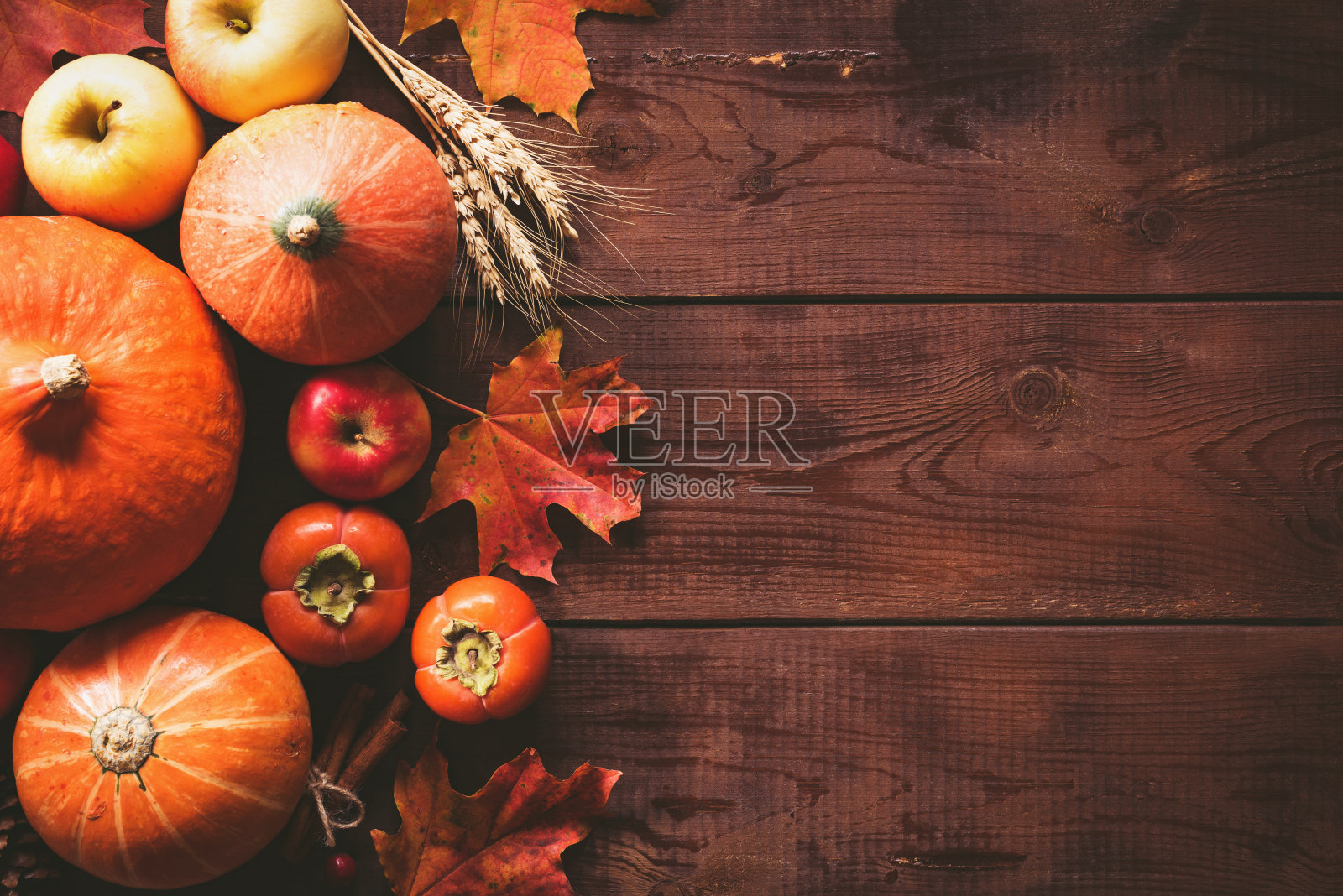 感恩节背景用南瓜、苹果和落叶放在木桌上照片摄影图片