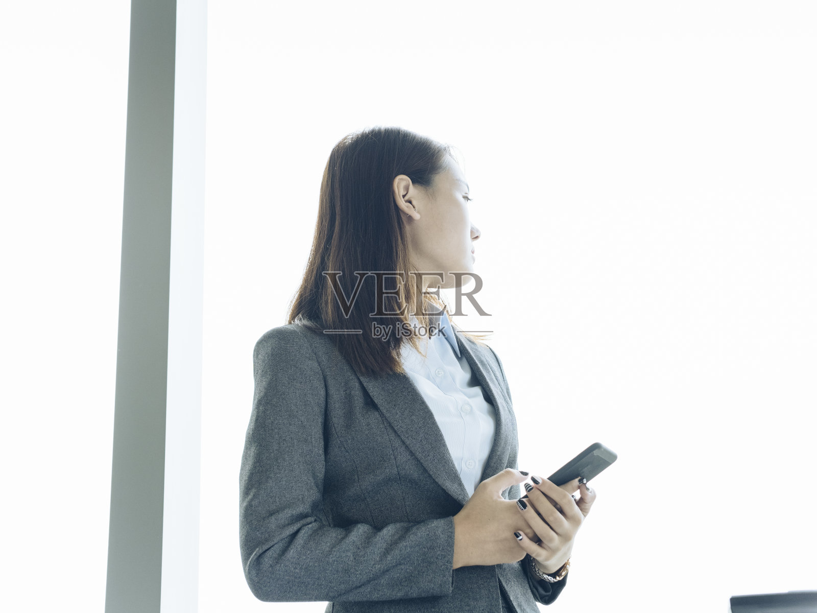 女人站在窗口使用智能手机照片摄影图片