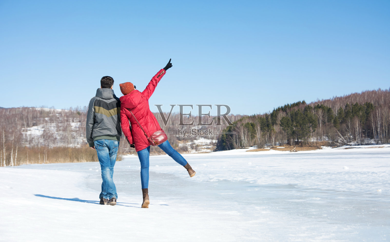 一对夫妇在结冰的湖面上散步照片摄影图片