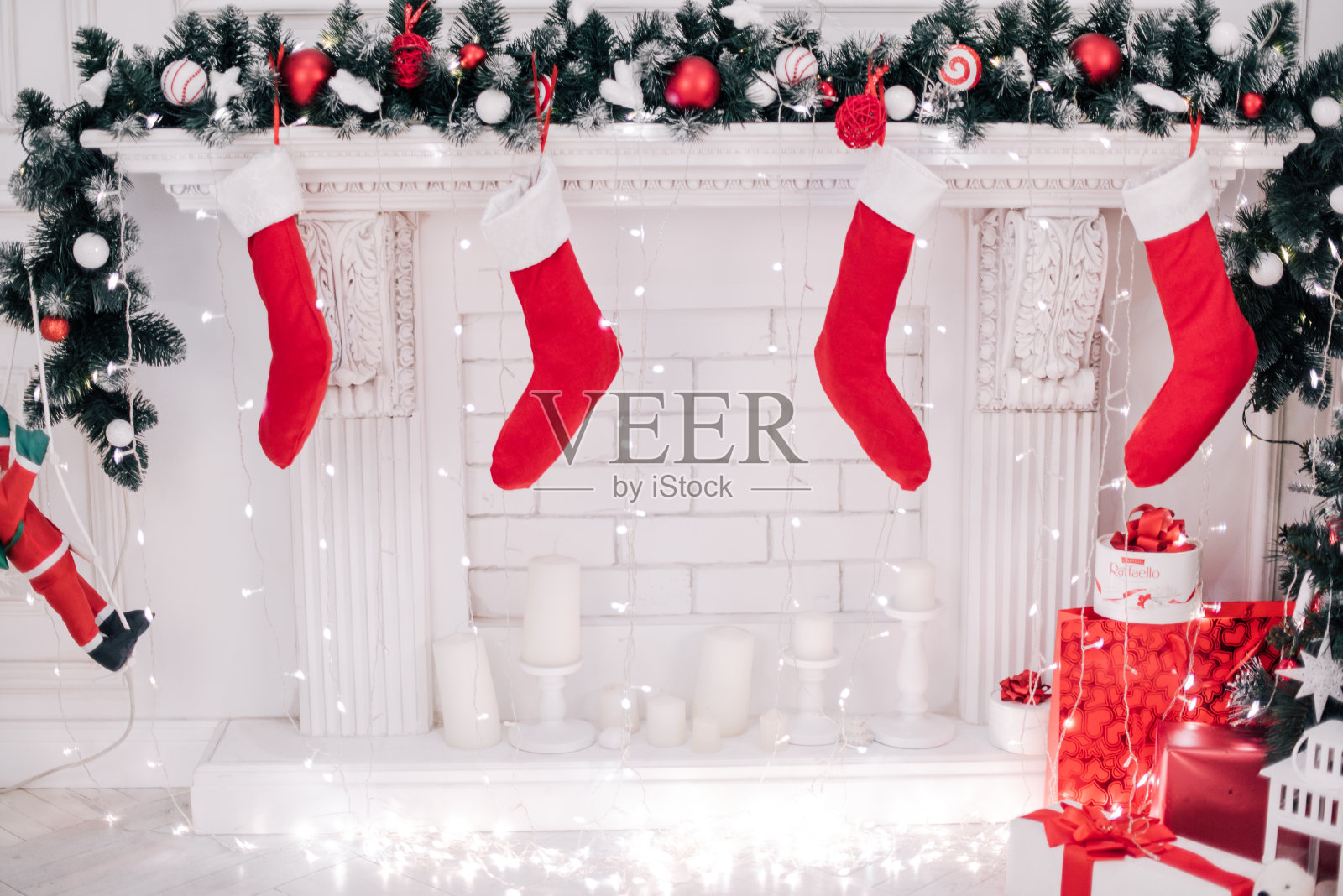 一个漂亮的装饰明亮的红色圣诞袜挂在壁炉等待礼物的特写。照片摄影图片