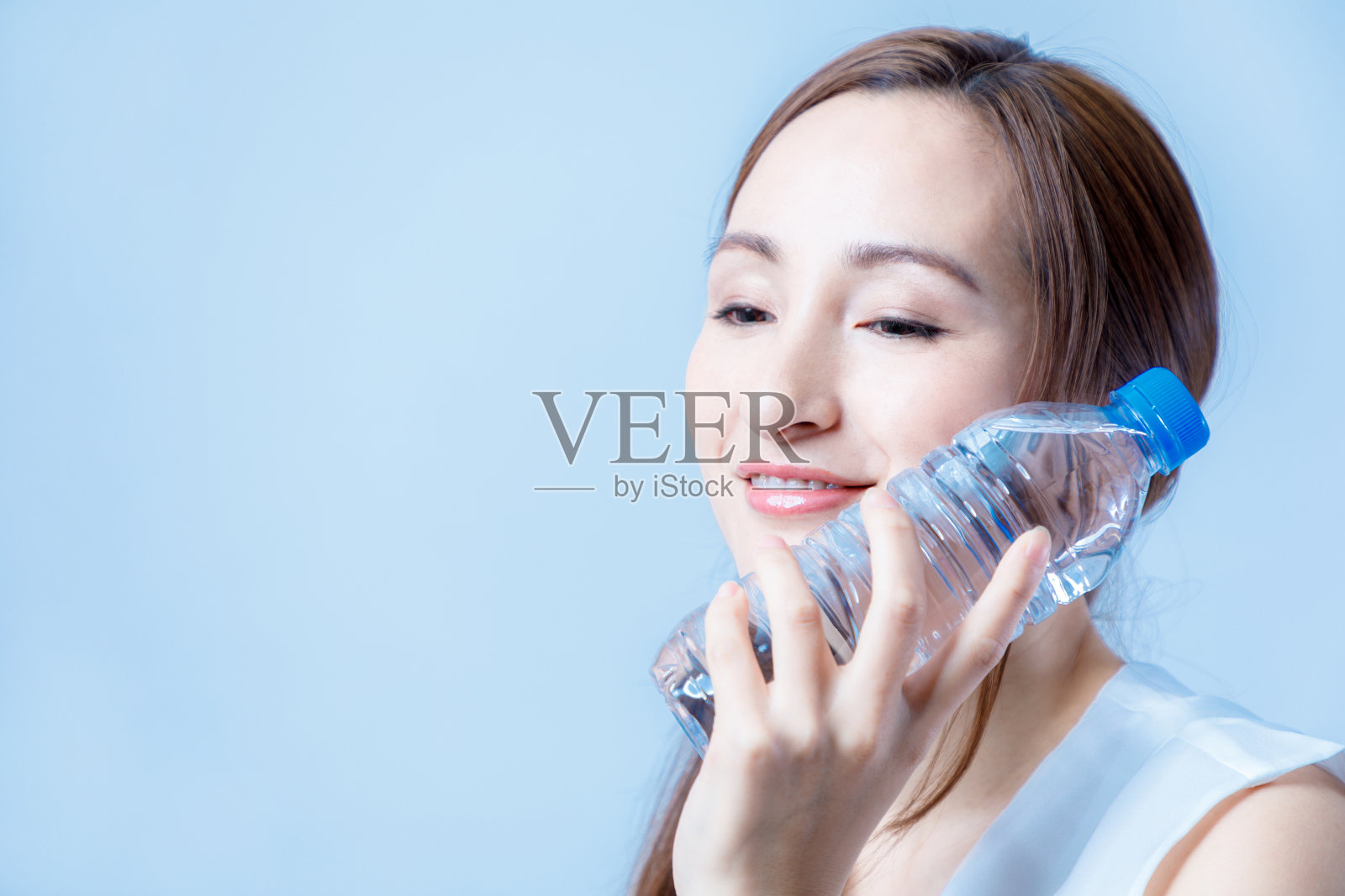 水合作用的概念。一个年轻的女人在喝一瓶水。照片摄影图片