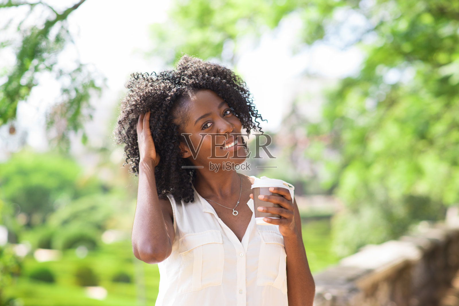 快乐的女人，一边喝咖啡一边弄乱头发照片摄影图片