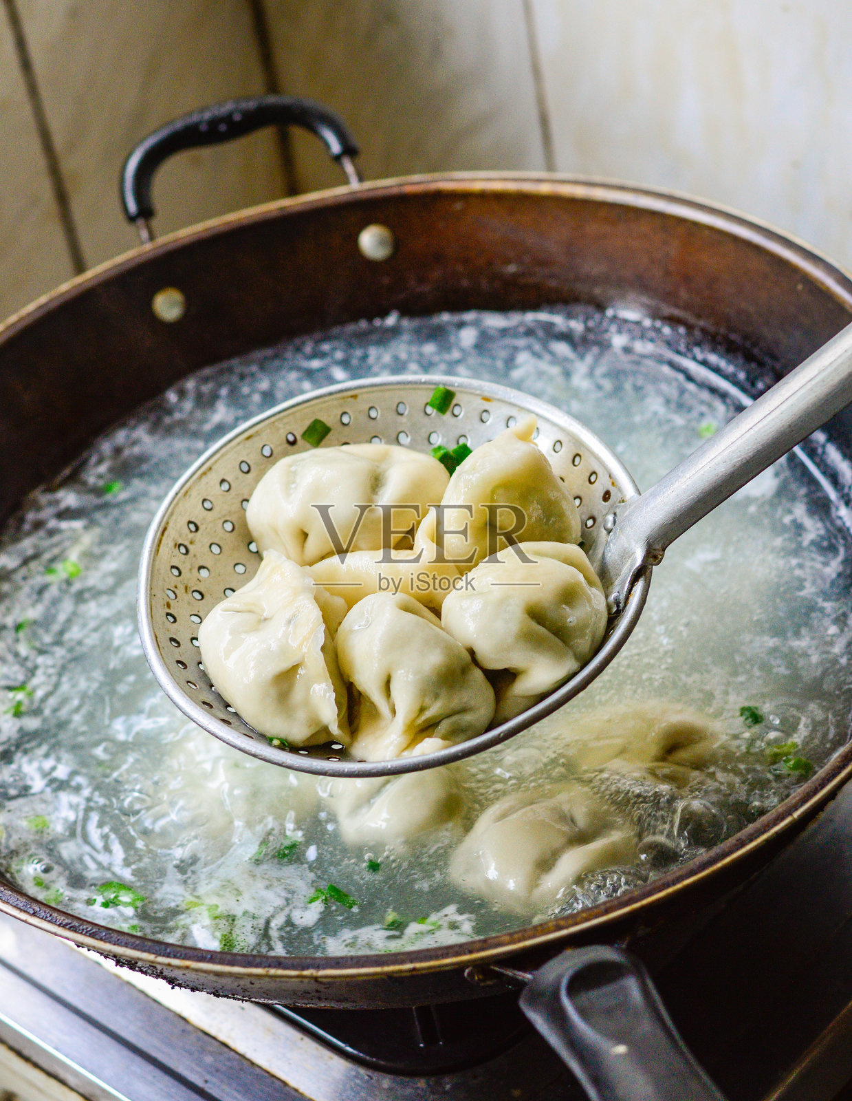 中国家庭在锅里煮饺子照片摄影图片
