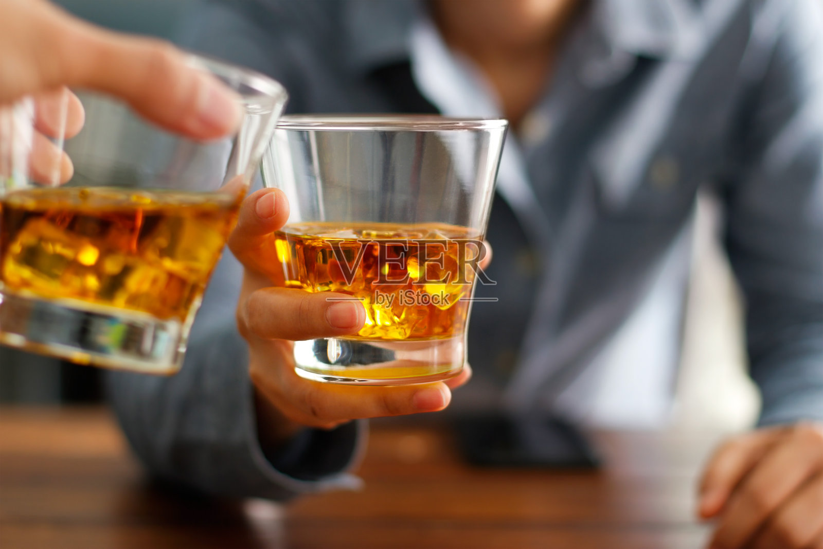 特写两名男子碰杯威士忌酒一起在柜台在酒吧照片摄影图片