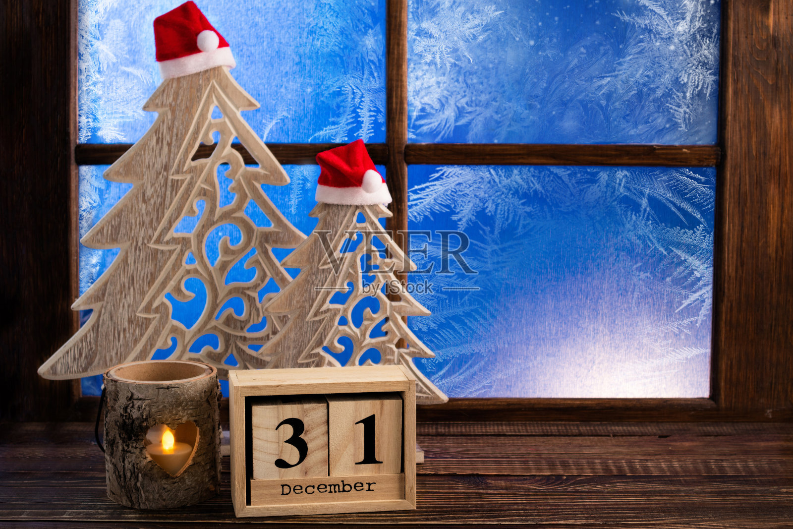 新年的背景。新年快乐。挂着圣诞装饰的霜花窗和圣诞树照片摄影图片