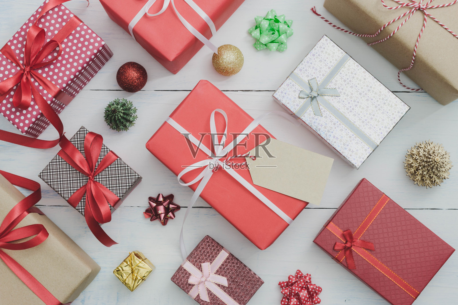 纸标签与圣诞和新年假期礼物盒装饰装饰在白色木制桌子上。礼物和祝贺的概念。照片摄影图片