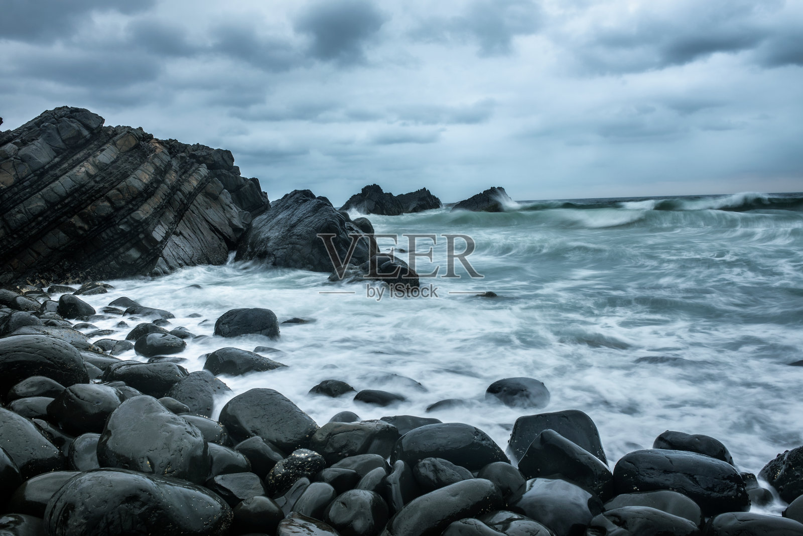 在澳大利亚附近的海滩新月头的岩石形成照片摄影图片