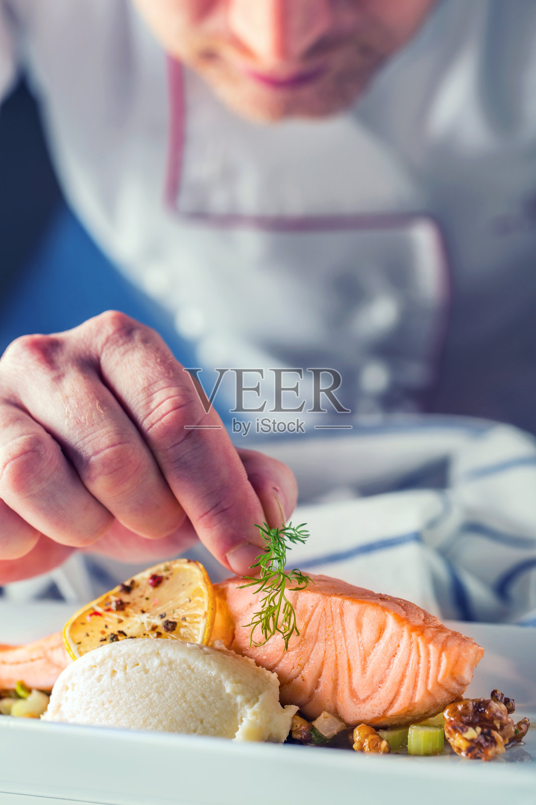 厨师在酒店或餐厅厨房做饭，只用手。配以莳萝装饰的三文鱼排照片摄影图片