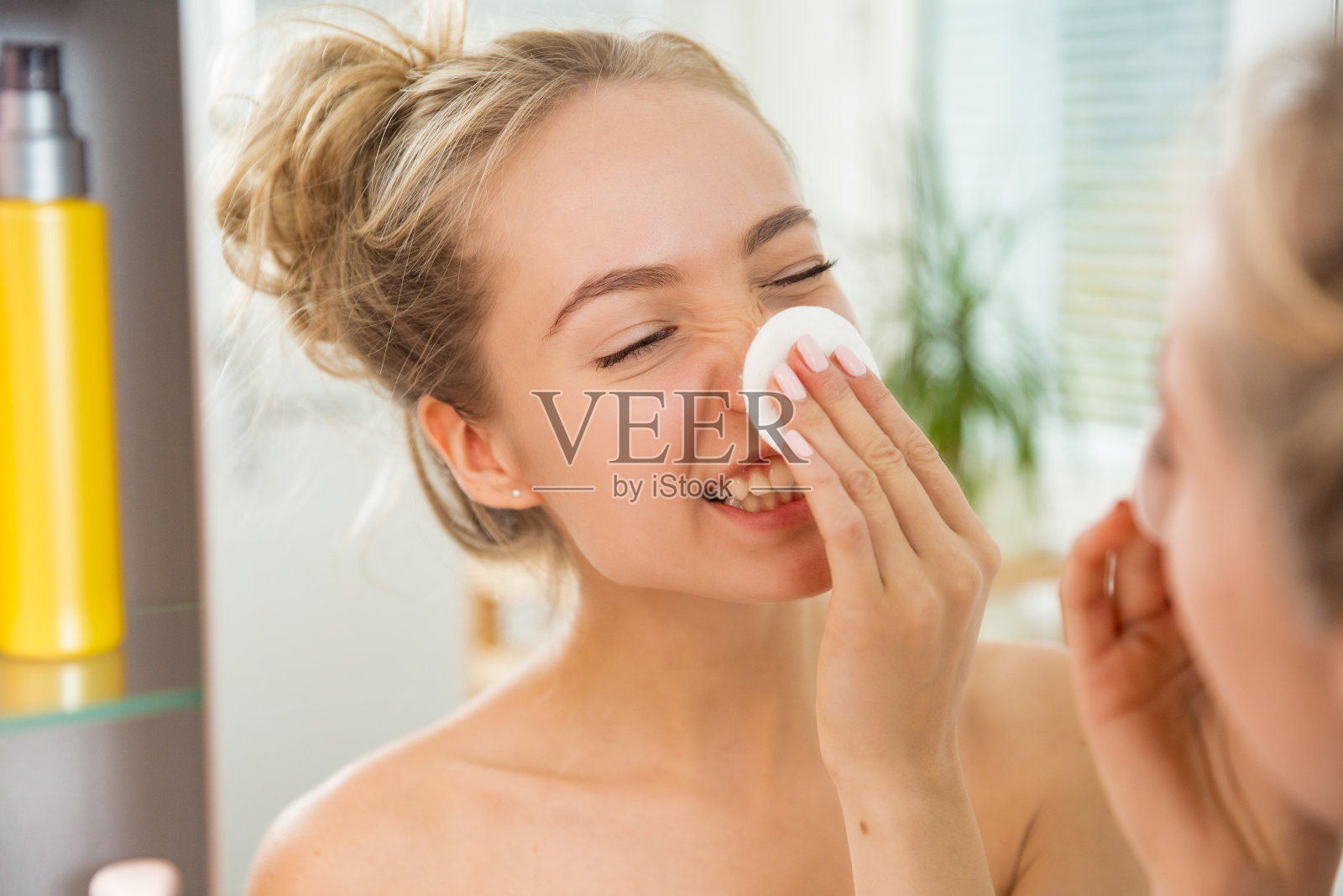 年轻漂亮的女子正在用化妆棉洗脸照片摄影图片