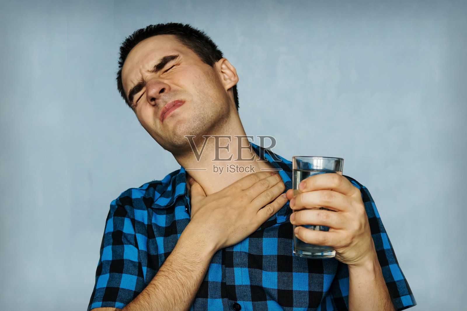 人像男子咳嗽着，用疼痛的表情压着胸部。照片摄影图片