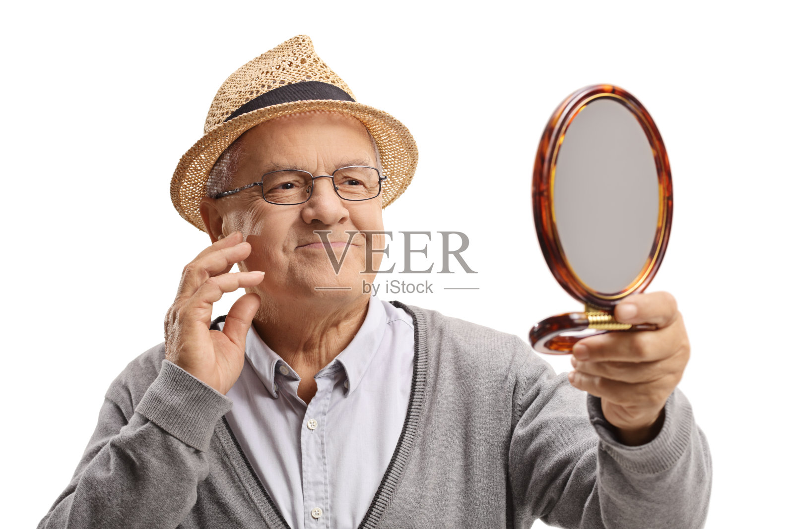 一个老人看着镜子里的自己，摸着自己的脸照片摄影图片