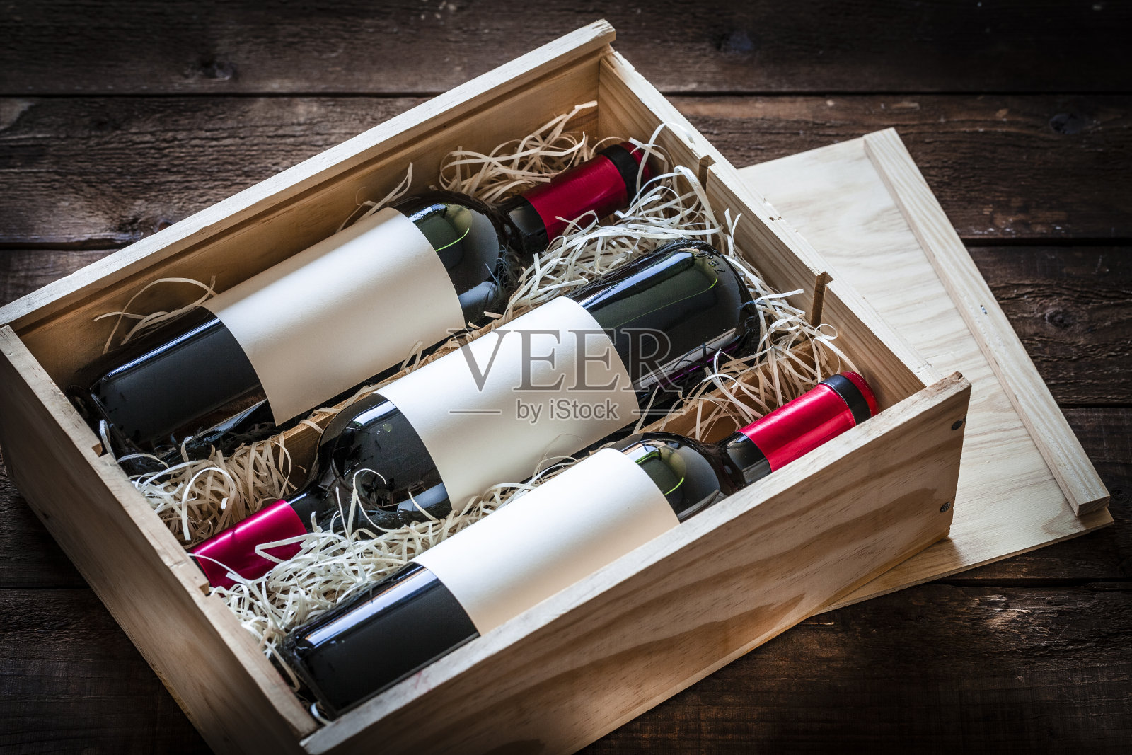 红酒瓶子装在一个木盒里，射在一张质朴的木桌上照片摄影图片