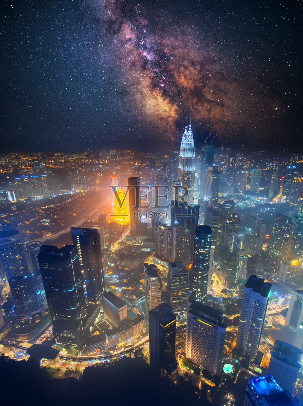 从空中俯瞰吉隆坡，马来西亚。城市的商业摩天大楼，夜晚的市中心和天空中的银河照片摄影图片