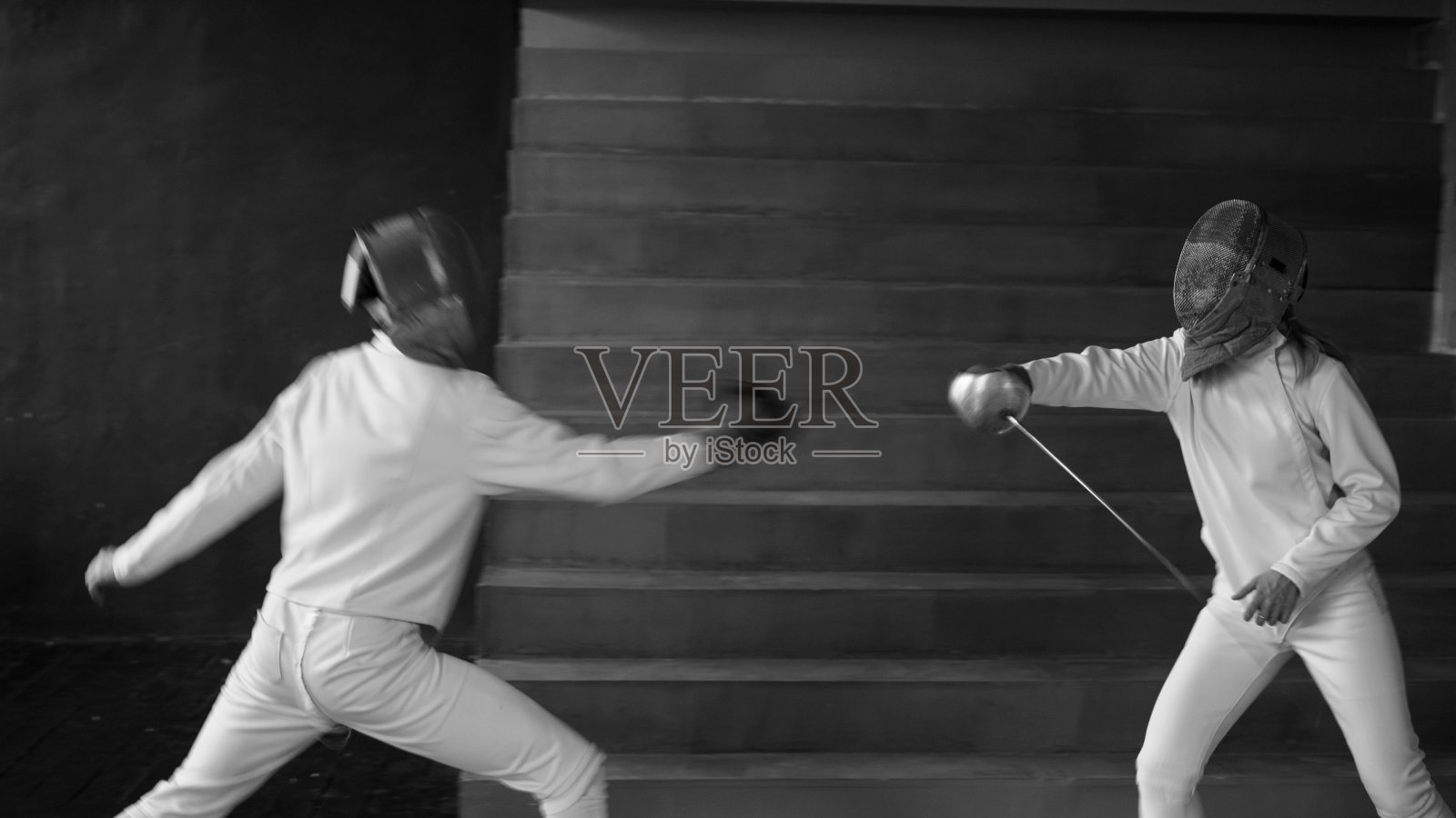 两名击剑运动员在室内进行击剑比赛照片摄影图片