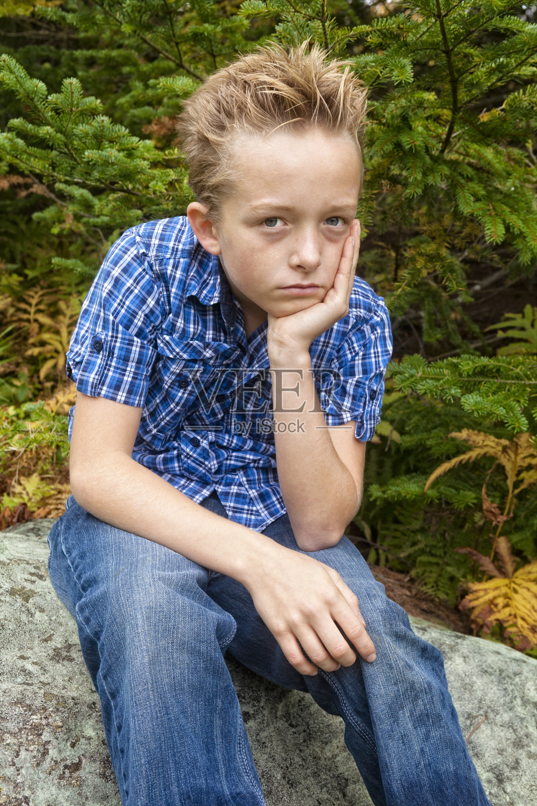 小男孩坐在树林里沉思照片摄影图片