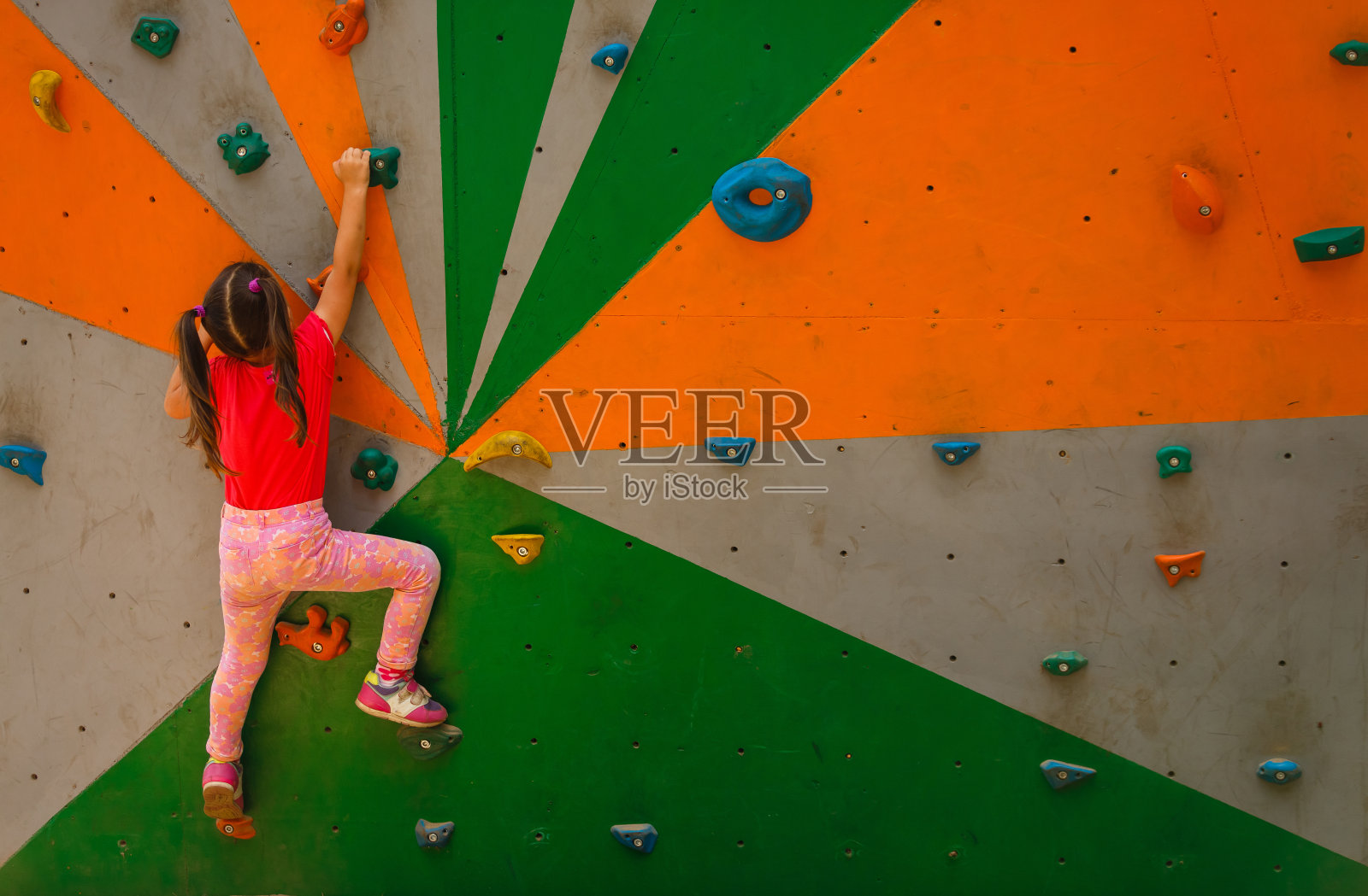 小女孩爬到墙顶的运动形象照片摄影图片