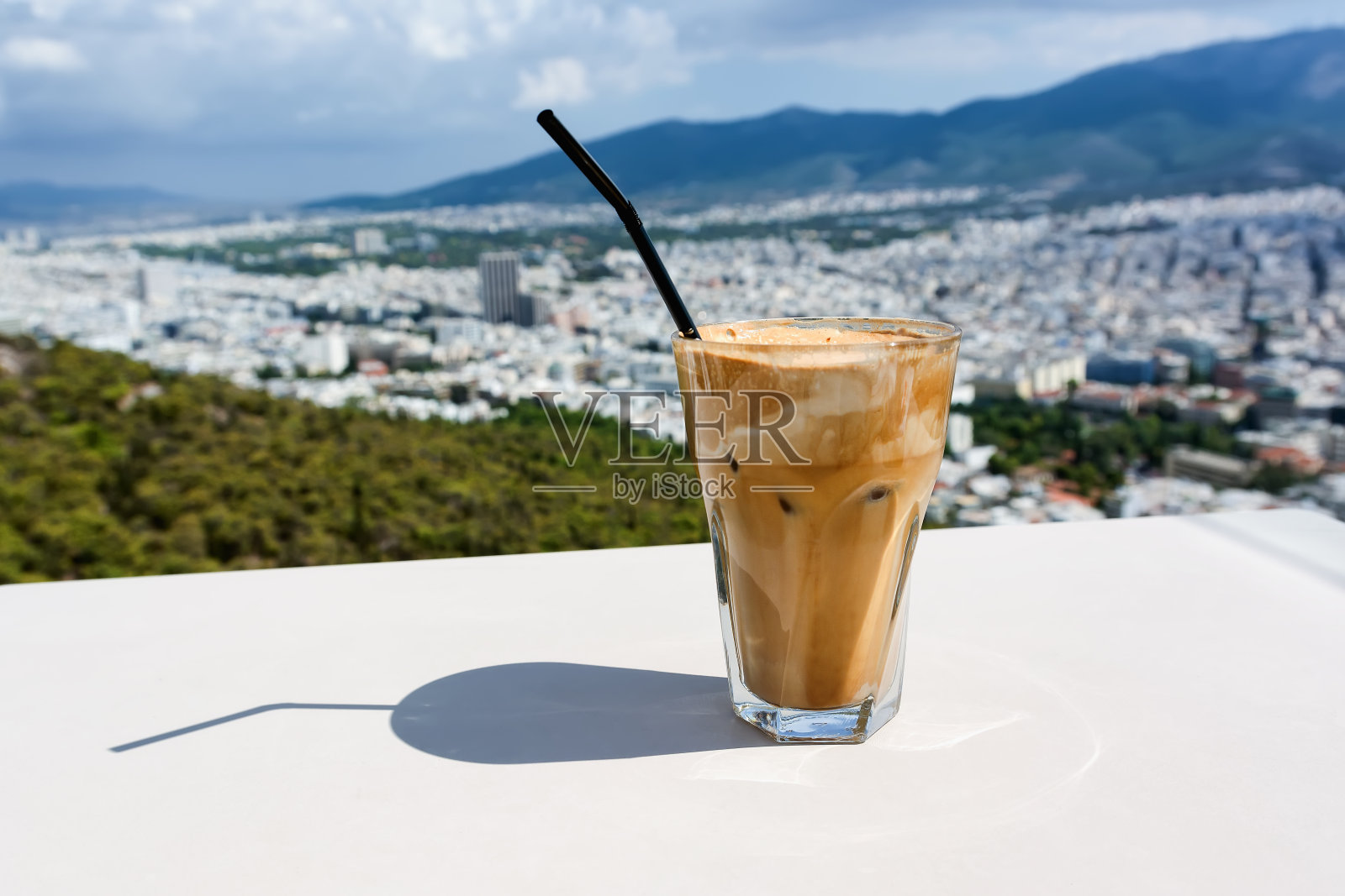 以冰冰咖啡和雅典城为背景。照片摄影图片